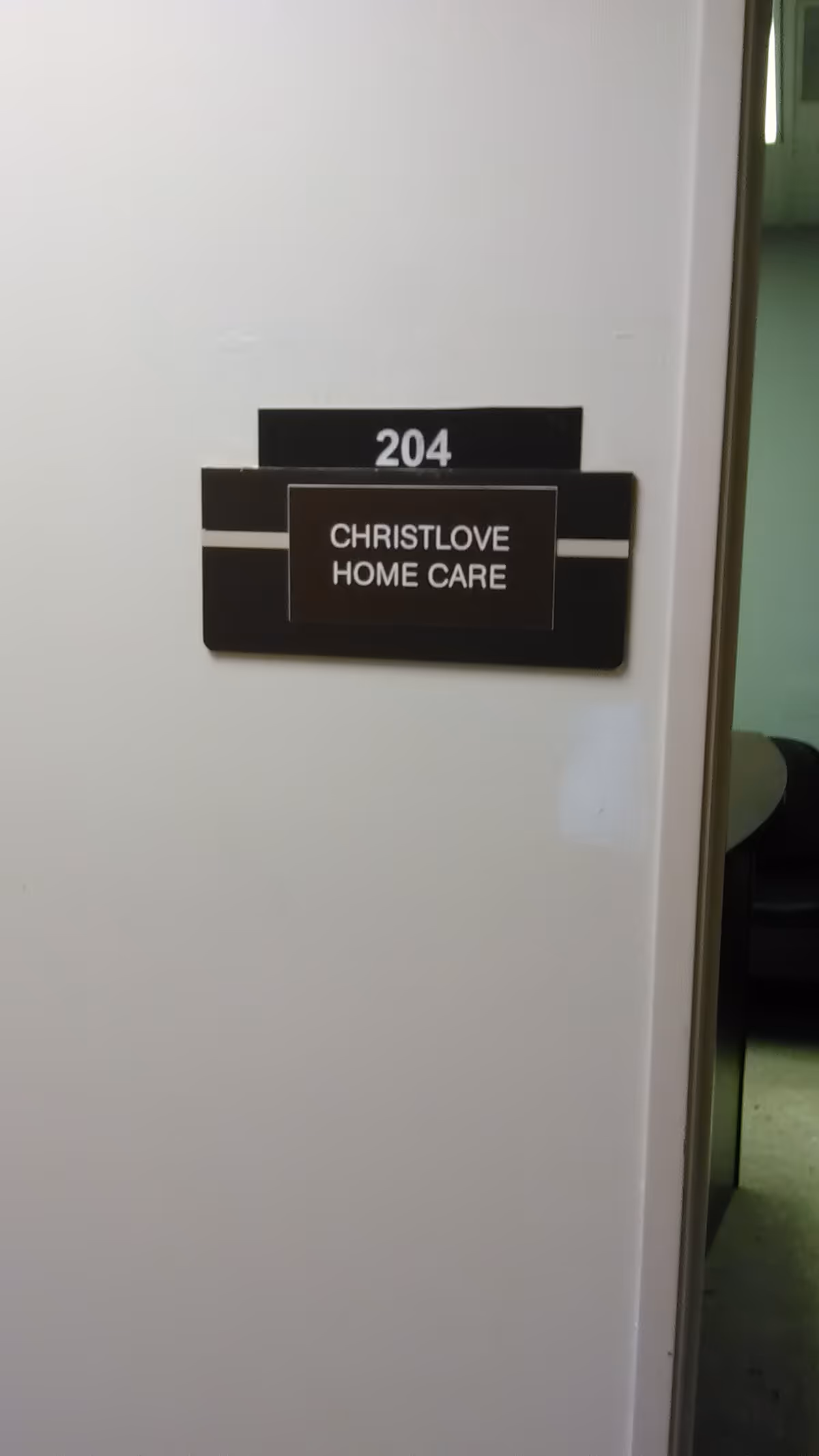 Wall plaque shows room 204 for CHRISTLOVE HOME CARE in a hallway.