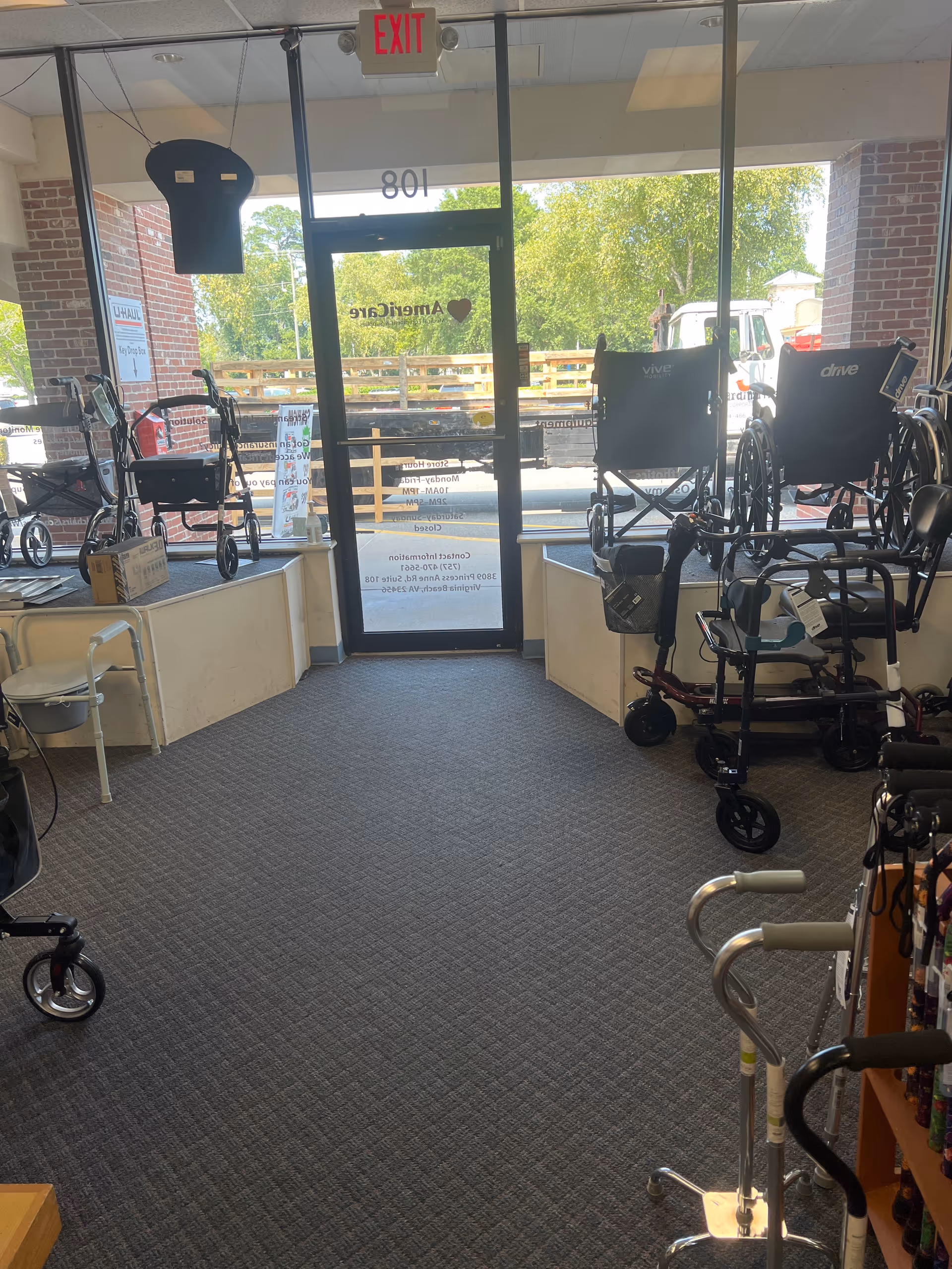 Indoor showroom at facility entrance displaying mobility aids and wheelchairs near glass doors.