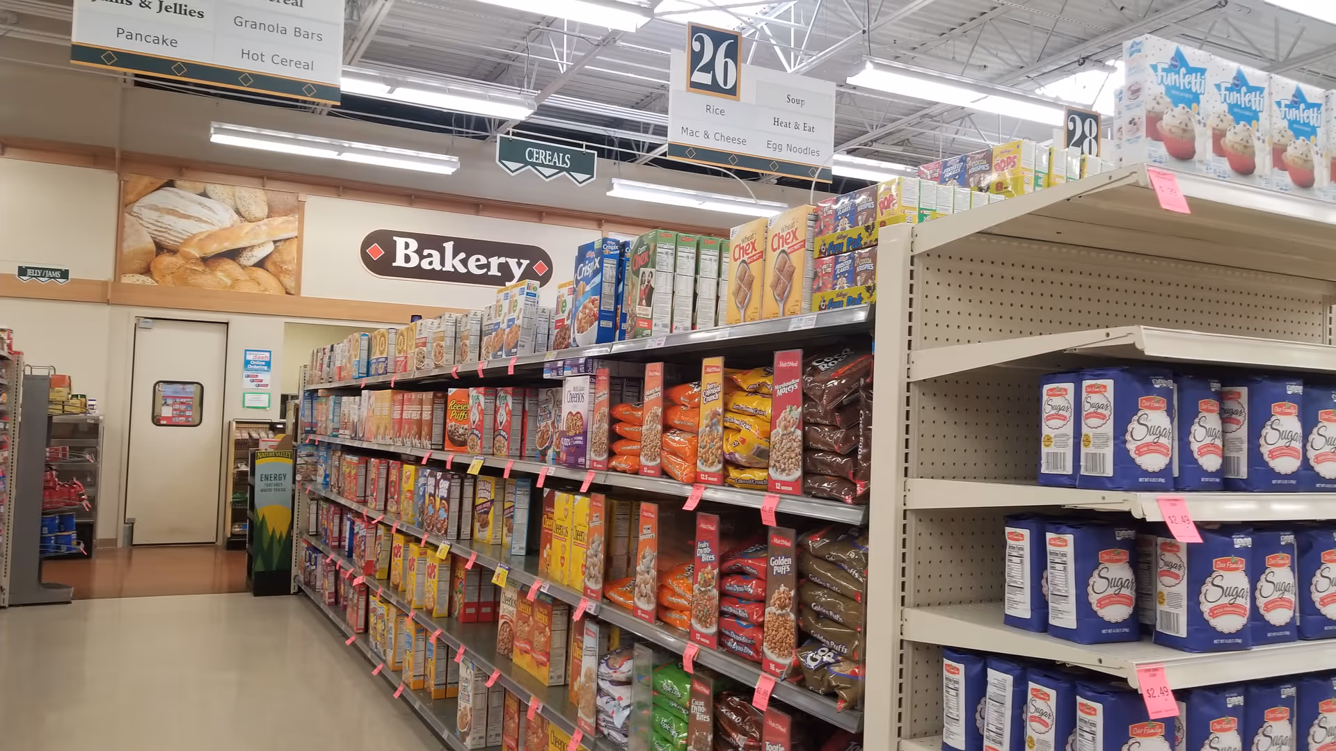 Interior of a Discount Drug Mart store aisle with cereal boxes and bakery signage.