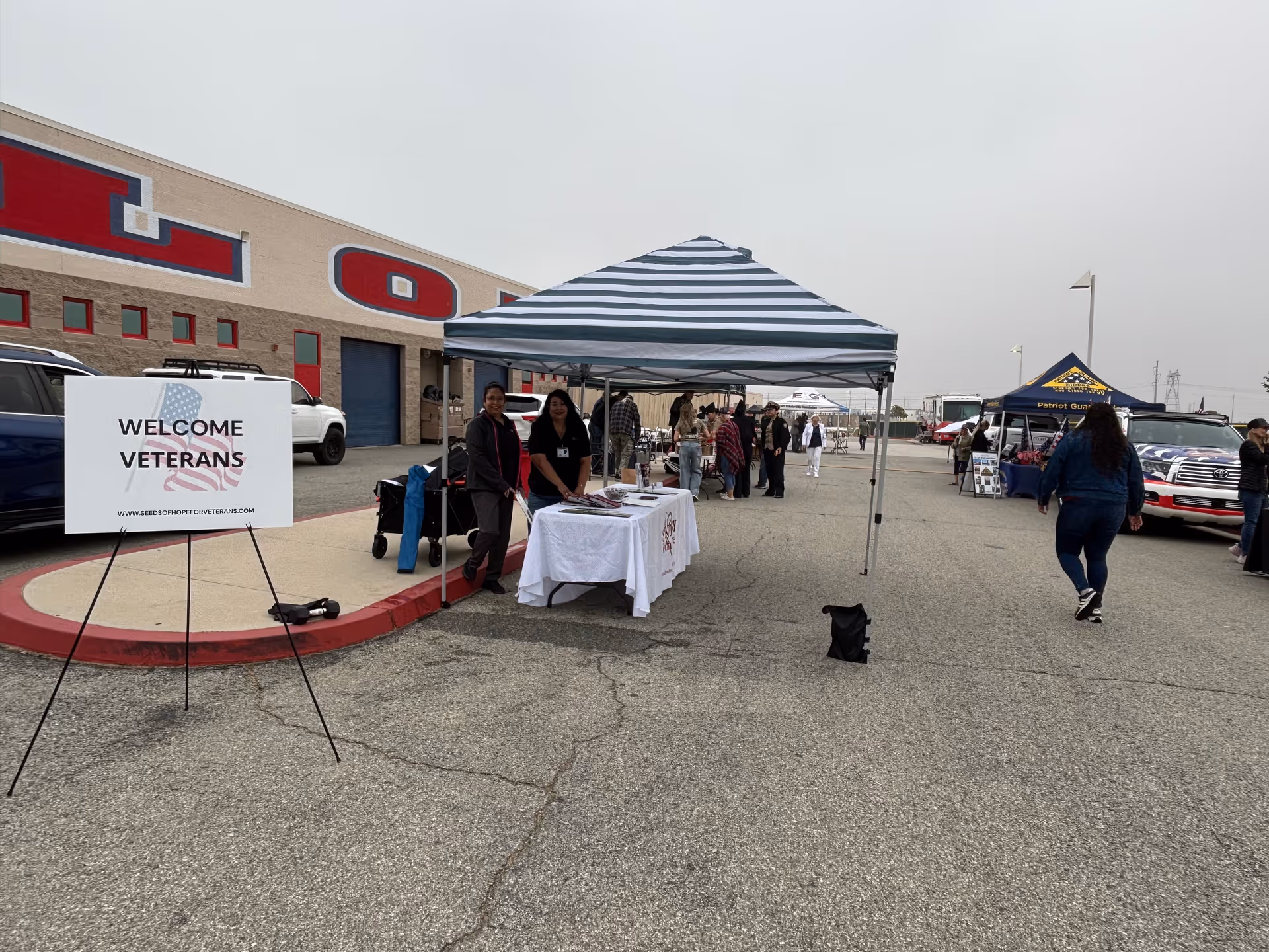 Outdoor event at a facility with tents, tables, and a Welcome Veterans sign.
