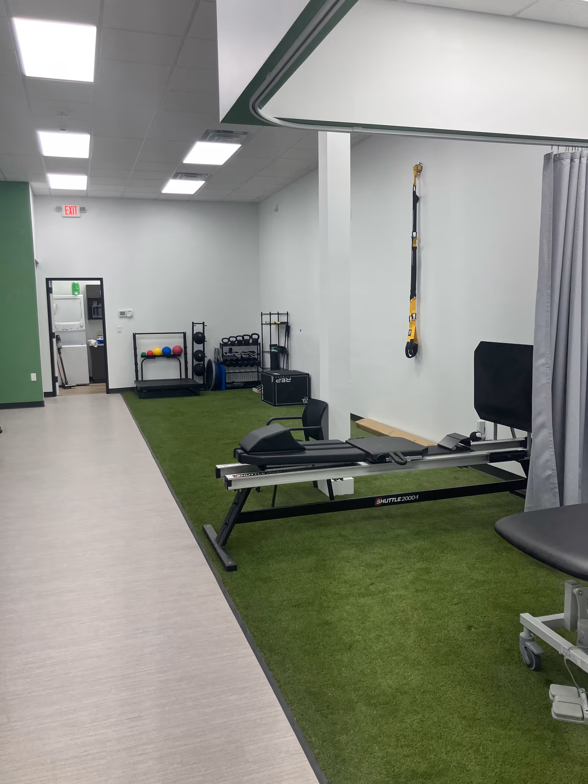 Rehabilitation gym in a senior living facility with treadmill, weights, and exercise equipment.