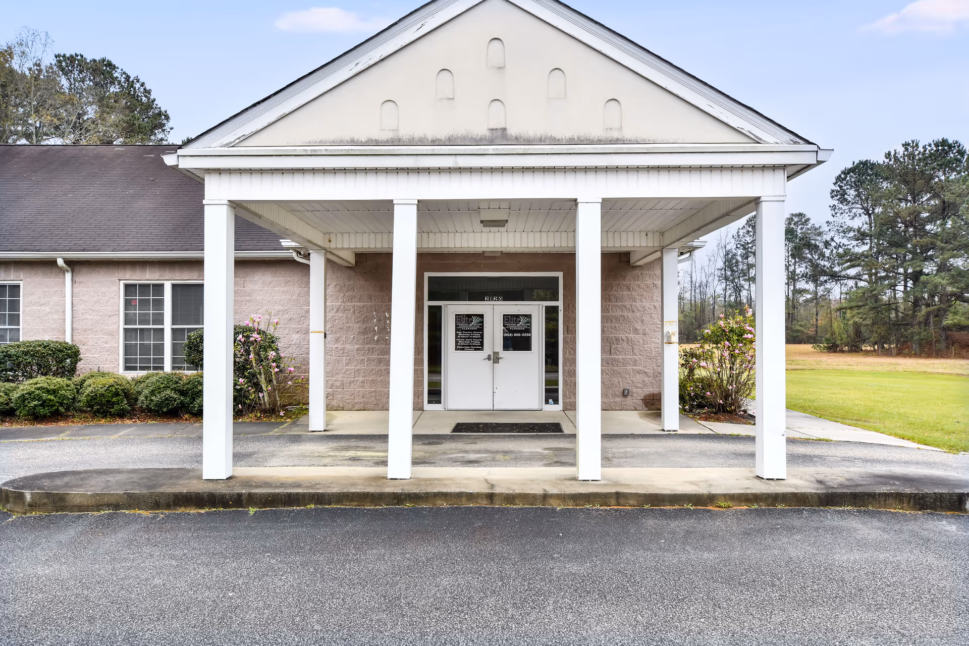 Front entrance of a single-story senior care building with a covered porch.