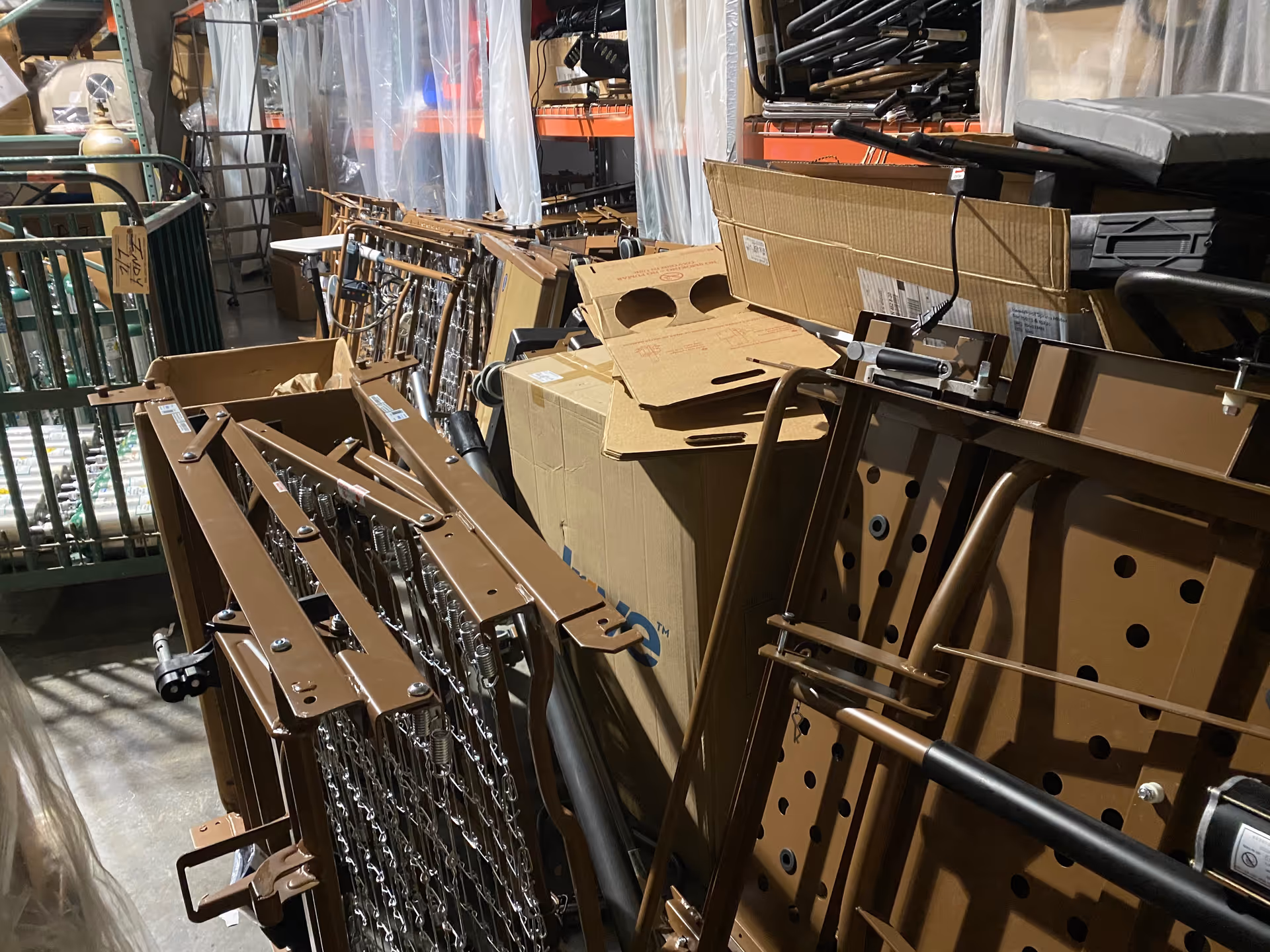 Interior storage area cluttered with brown metal frames, boxes, and equipment.