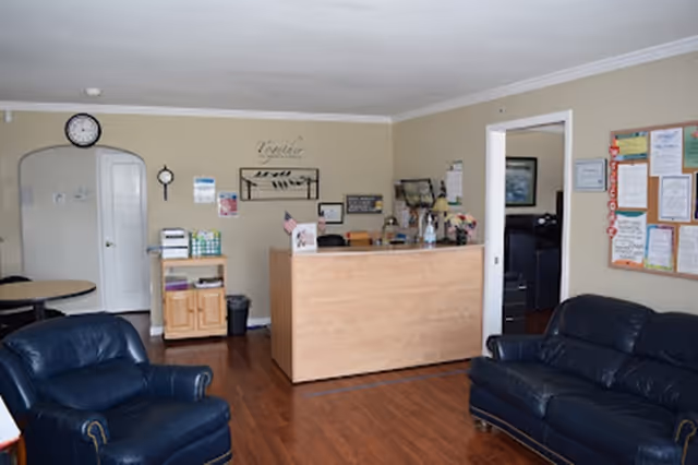 Reception desk in a cozy lounge with blue leather chairs and bulletin board.