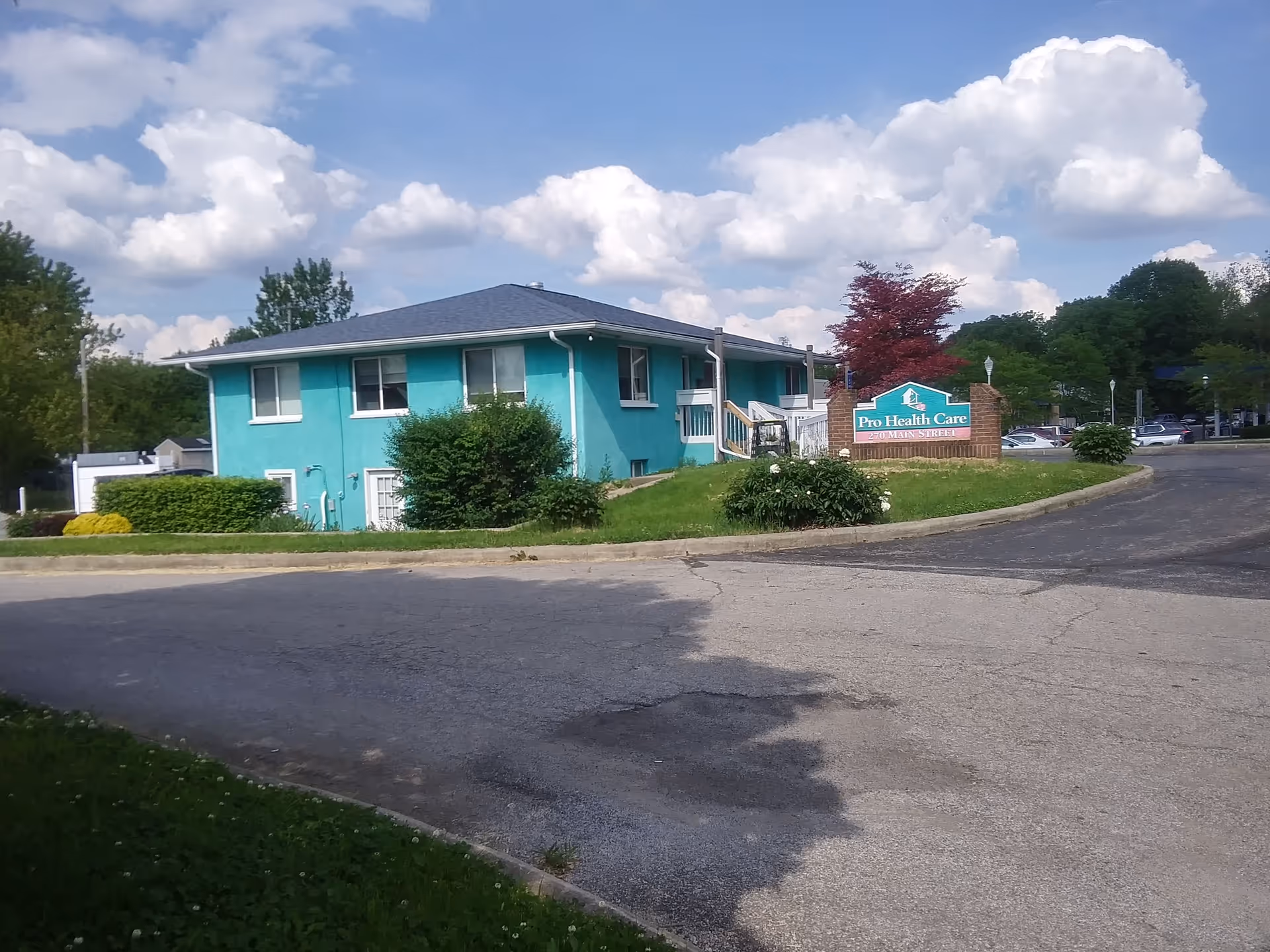 Turquoise, single-story senior care facility exterior with landscaping and a Pro Health Care sign.