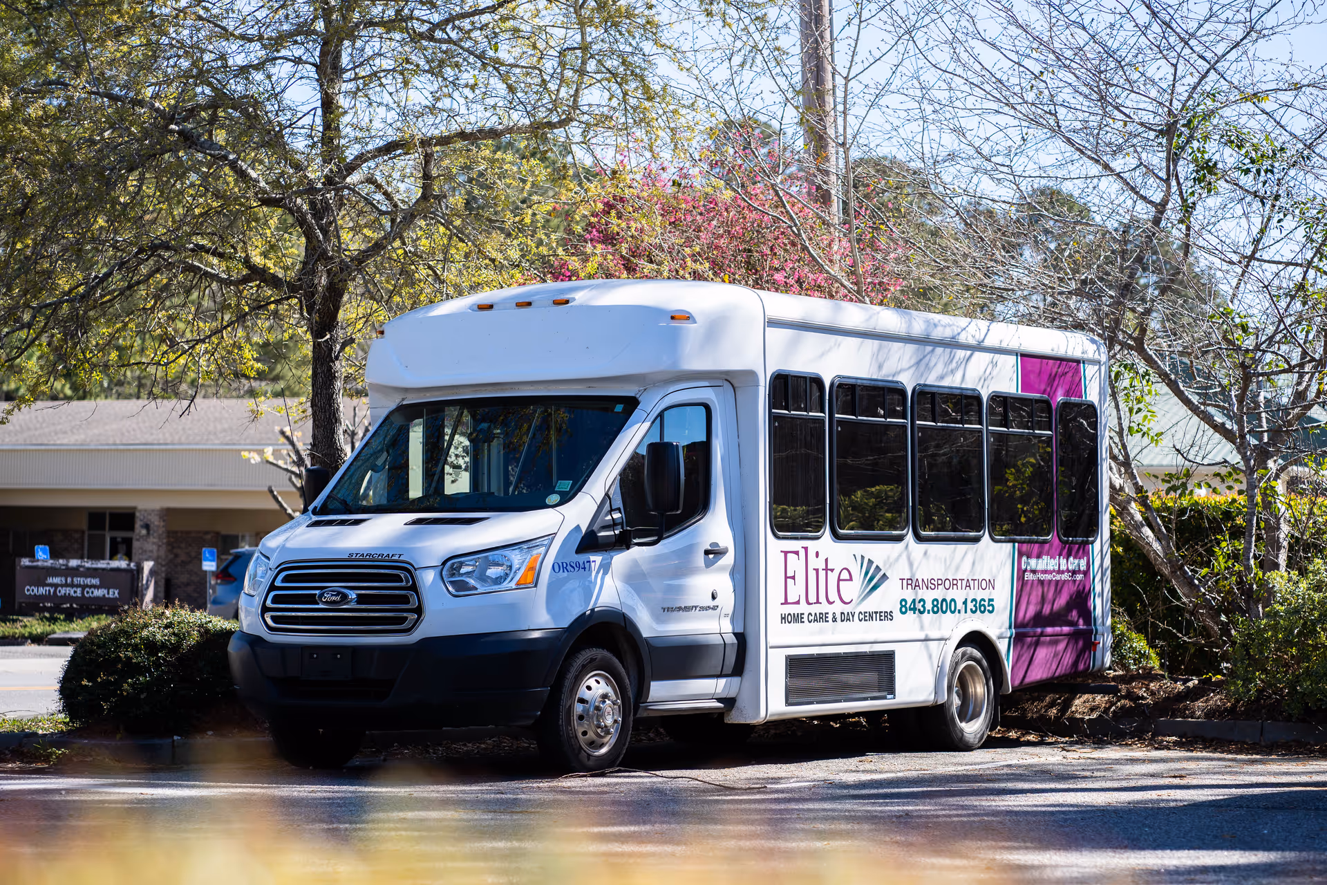 Elite Home Care and Day Centers transportation bus parked outside the facility.