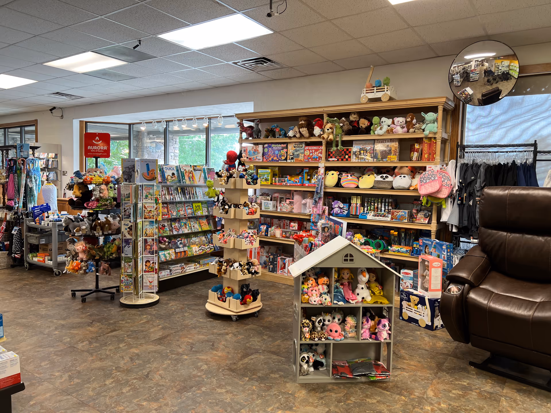Interior store space inside facility with toy shelves, clothing rack, and a leather chair.