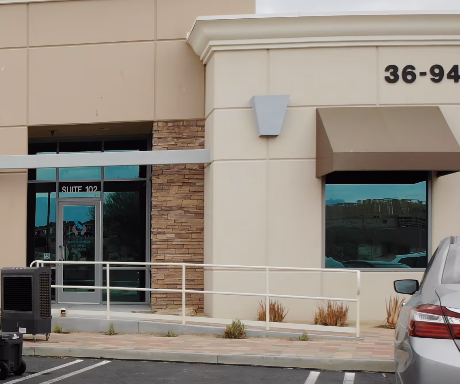Exterior view of Inland Respite facility entrance with ramp and a parked car.