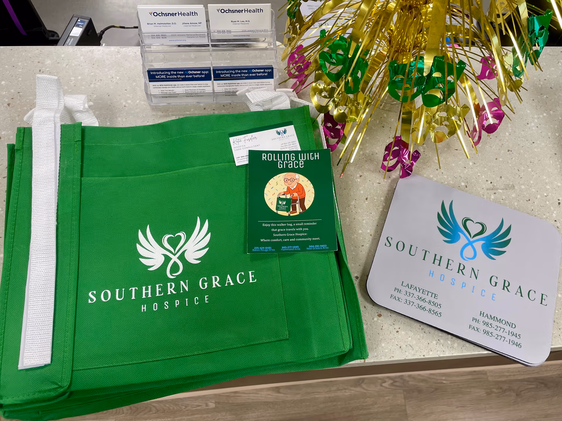Bright green Southern Grace Hospice tote bag and brochures on a reception counter.