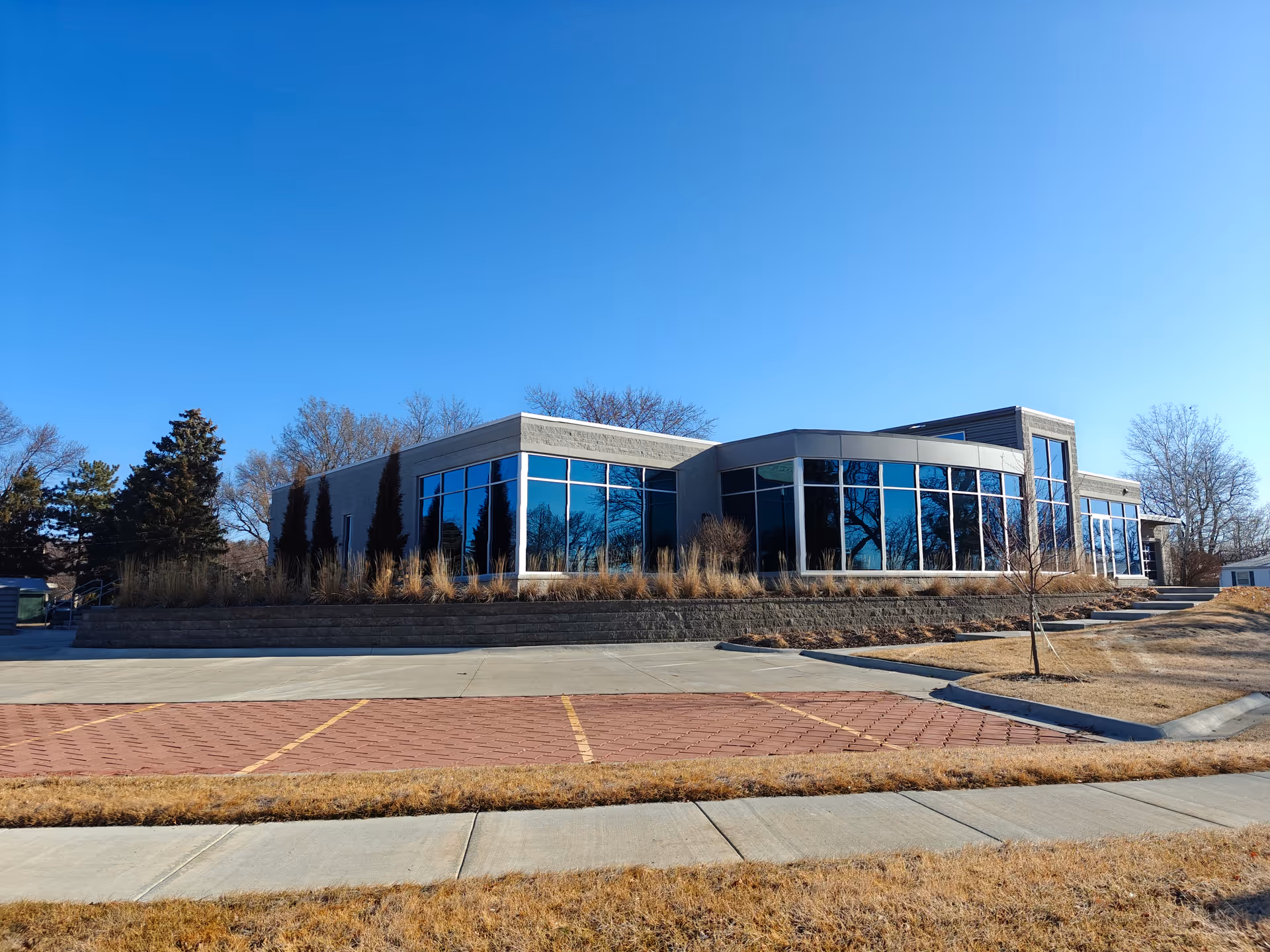 Modern senior care building with large glass windows and a landscaped front entry.