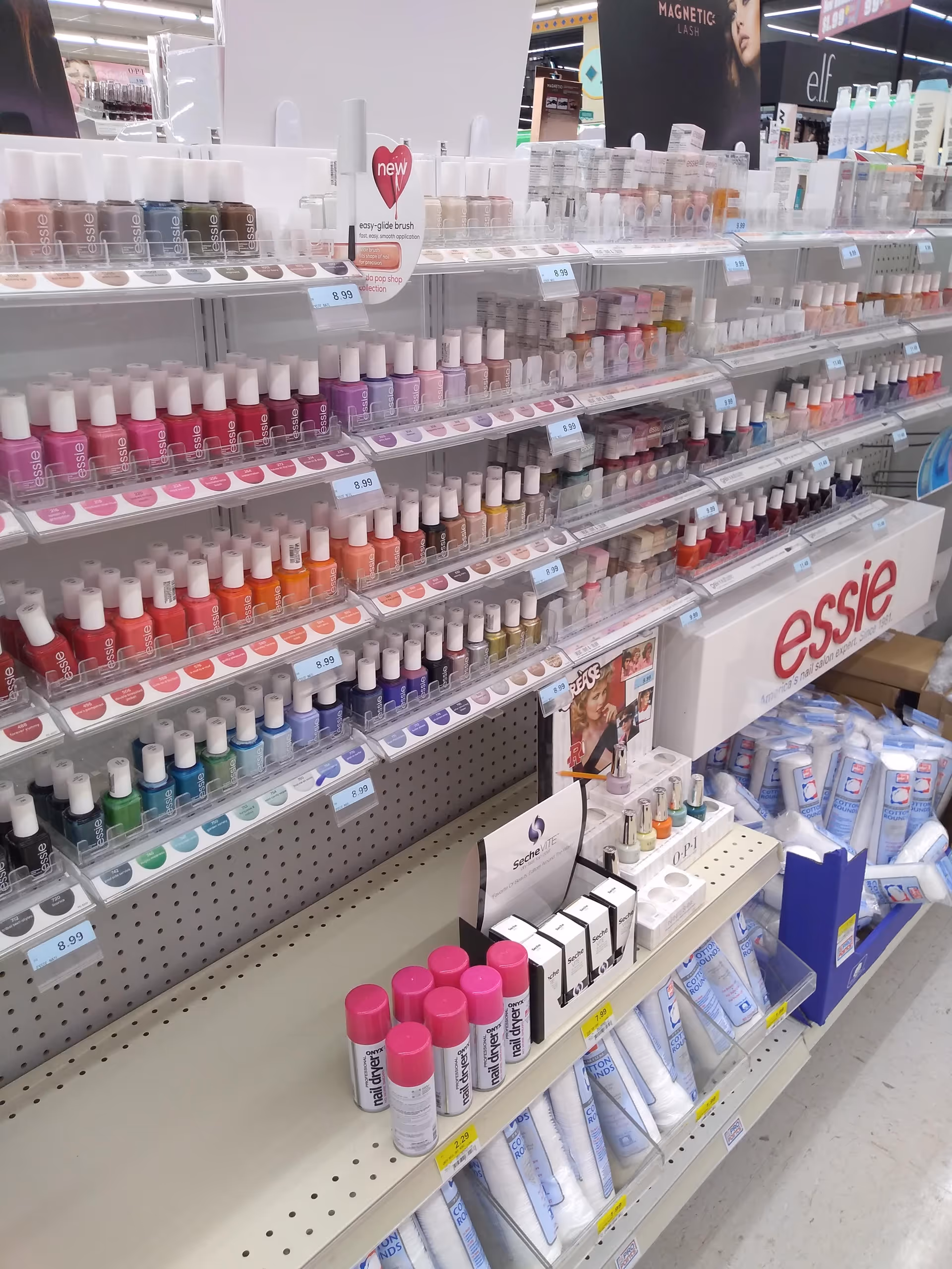 Store aisle with shelves of nail polish and beauty products.