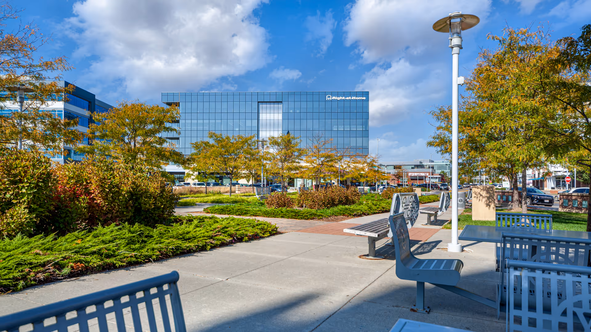 Outdoor plaza with benches and trees in front of Right At Home Corporate Headquarters.