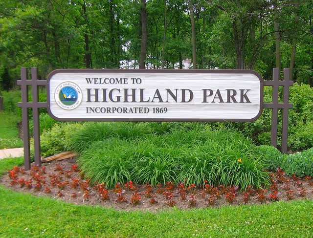 Outdoor sign reading Welcome to Highland Park with landscaped plants.