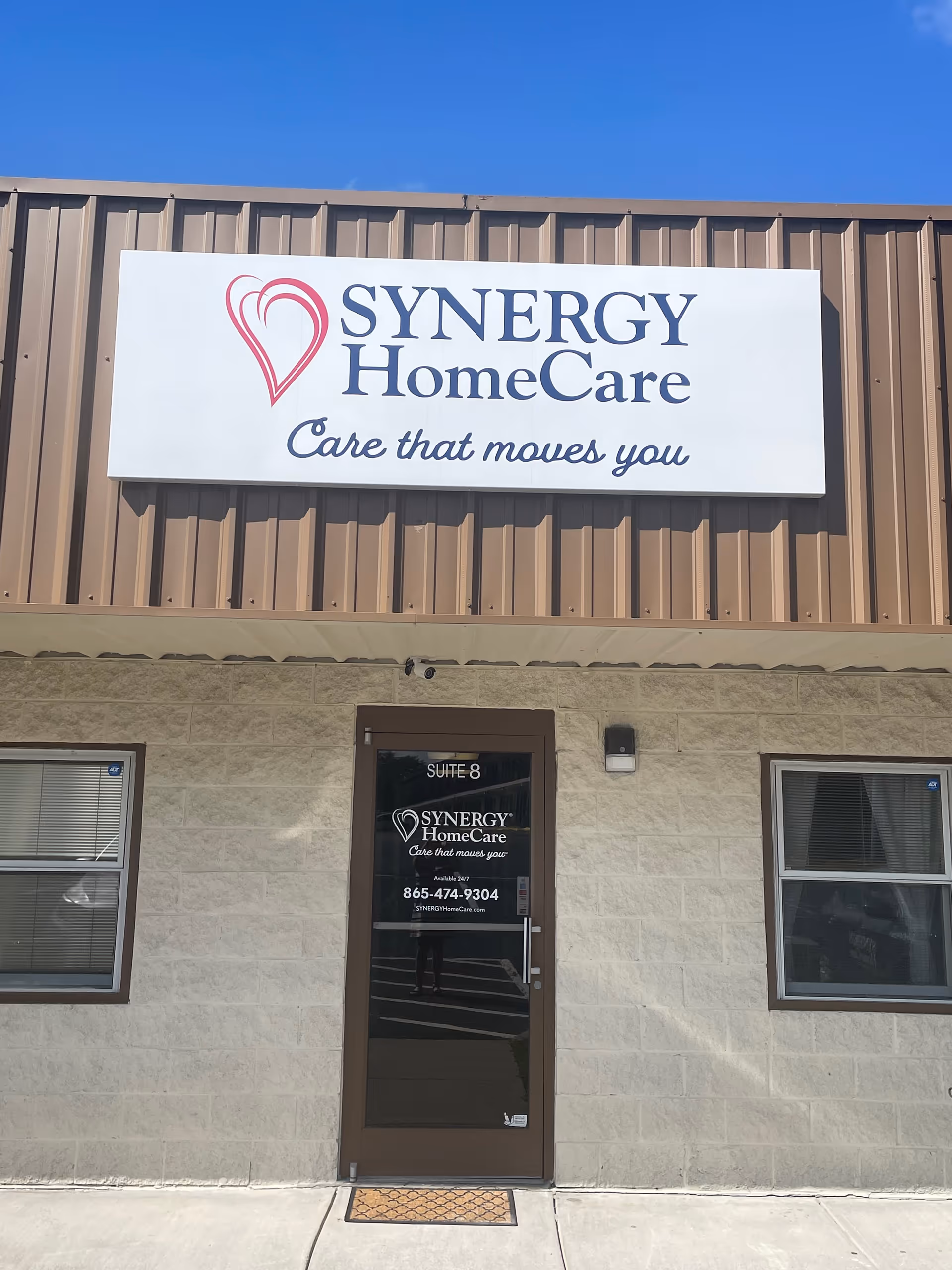 Exterior of a Synergy HomeCare building featuring a large sign and front door.