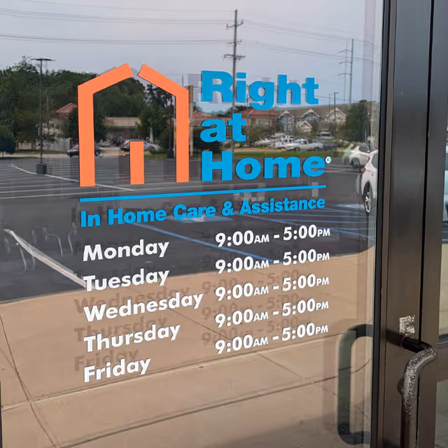 Glass entrance door displays Right at Home logo and daily operating hours with reflections
