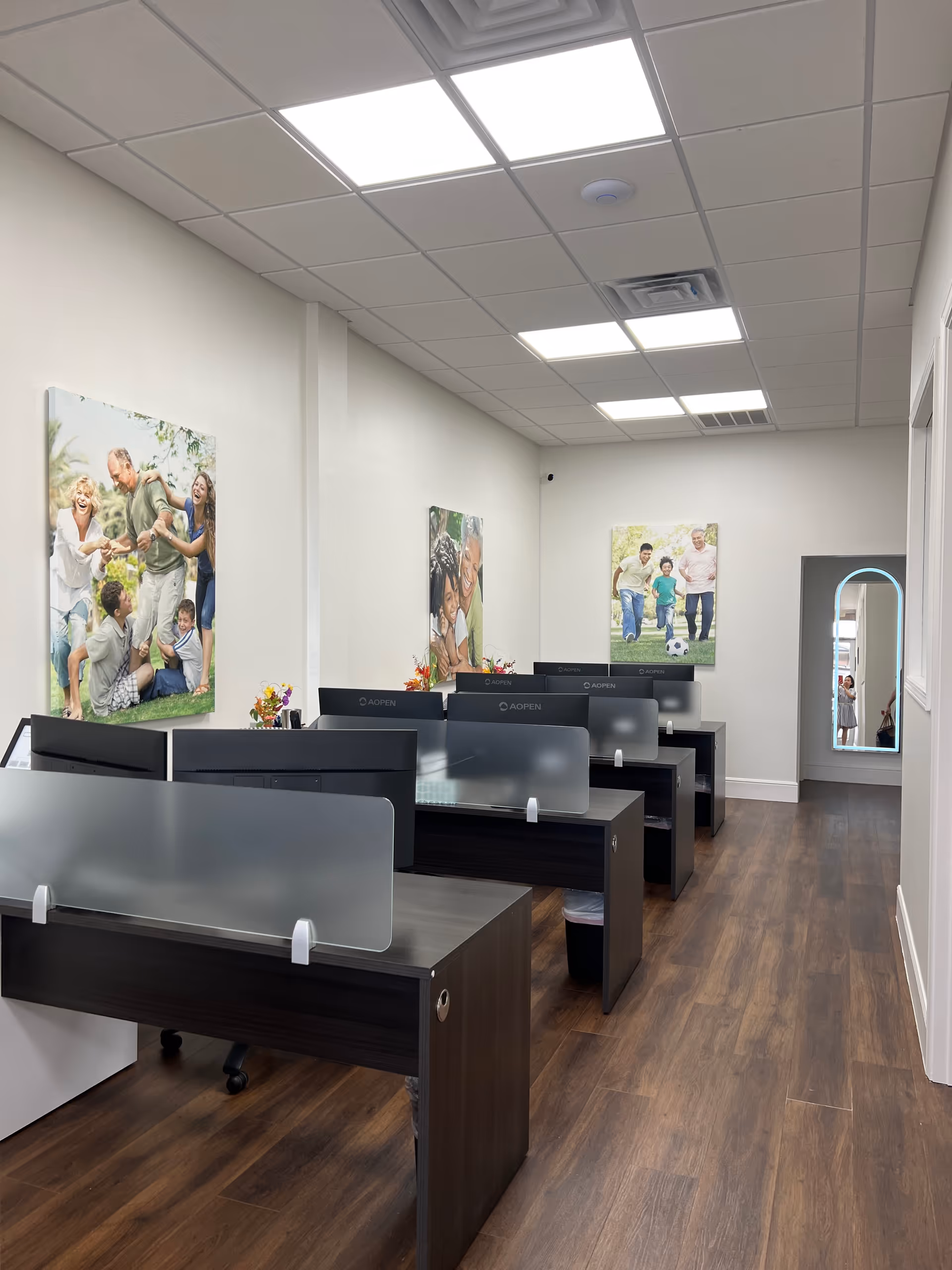 Interior office space with cubicles, frosted dividers, and wall posters.