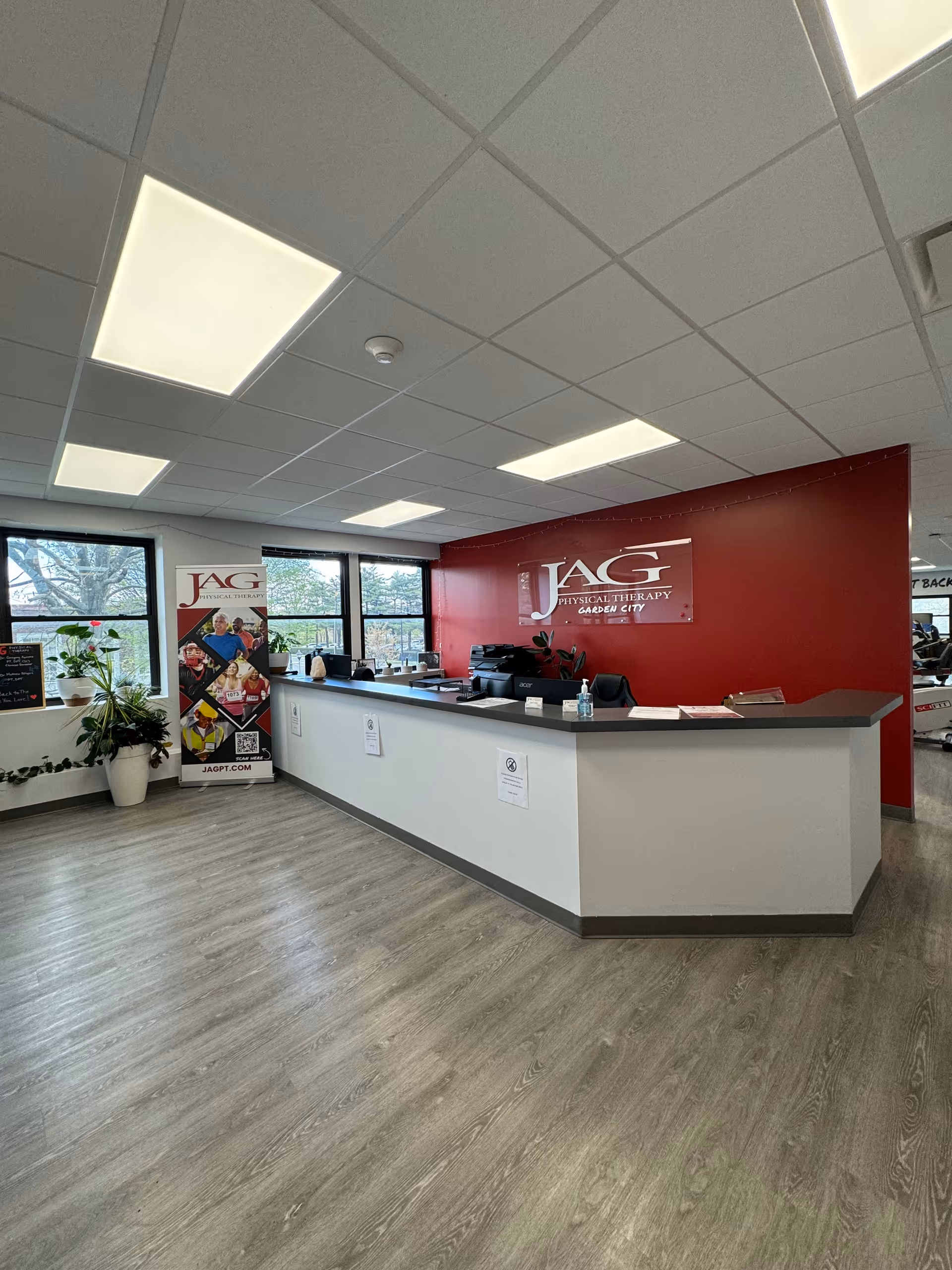 Reception area of JAG Physical Therapy with a long counter and red accent wall.