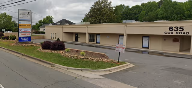 Exterior view of a beige senior living facility with signage near 635 Cox Road.