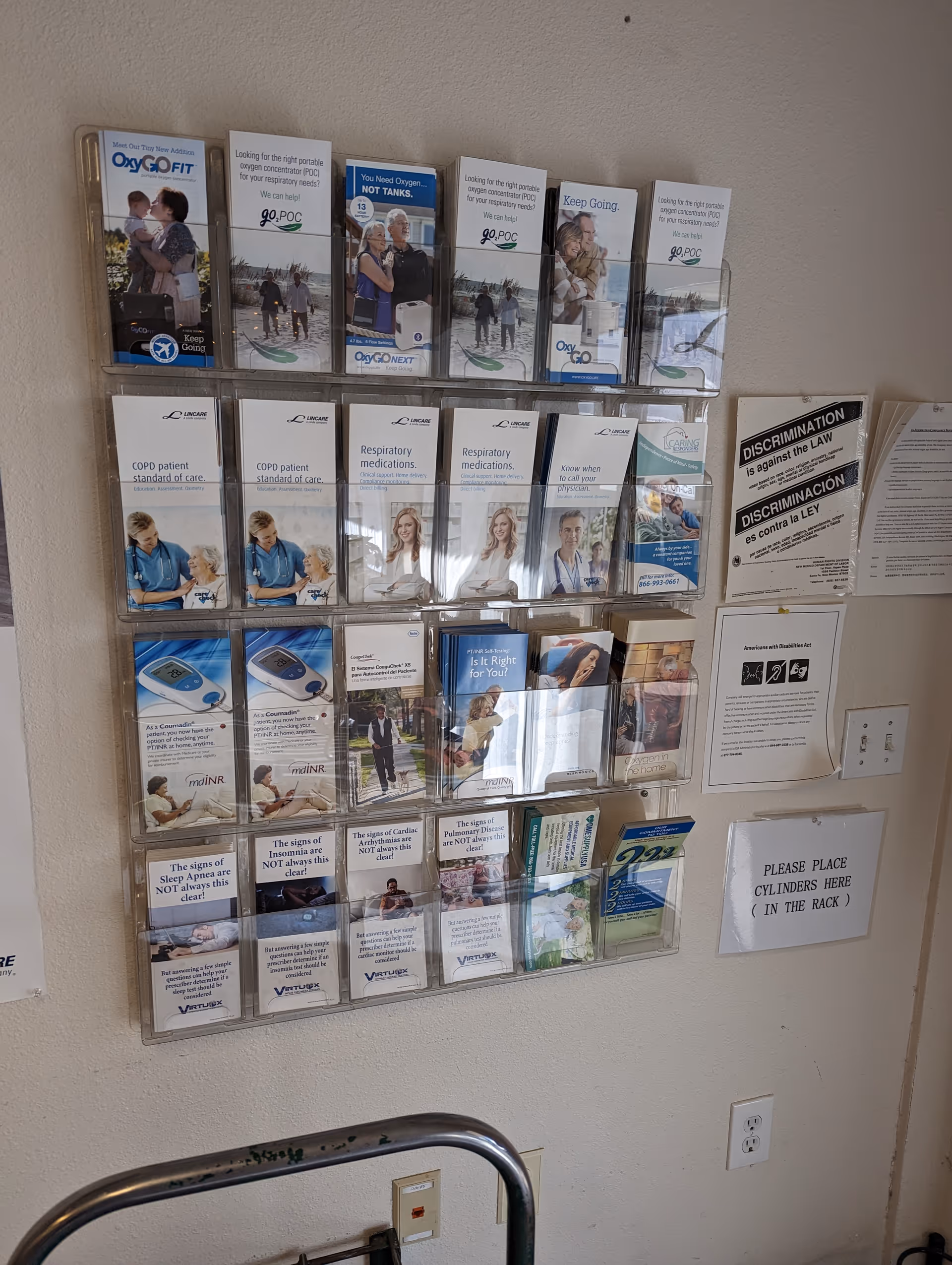 Multiple brochure racks mounted on a wall inside a facility, labeled LINCARE pamphlets.