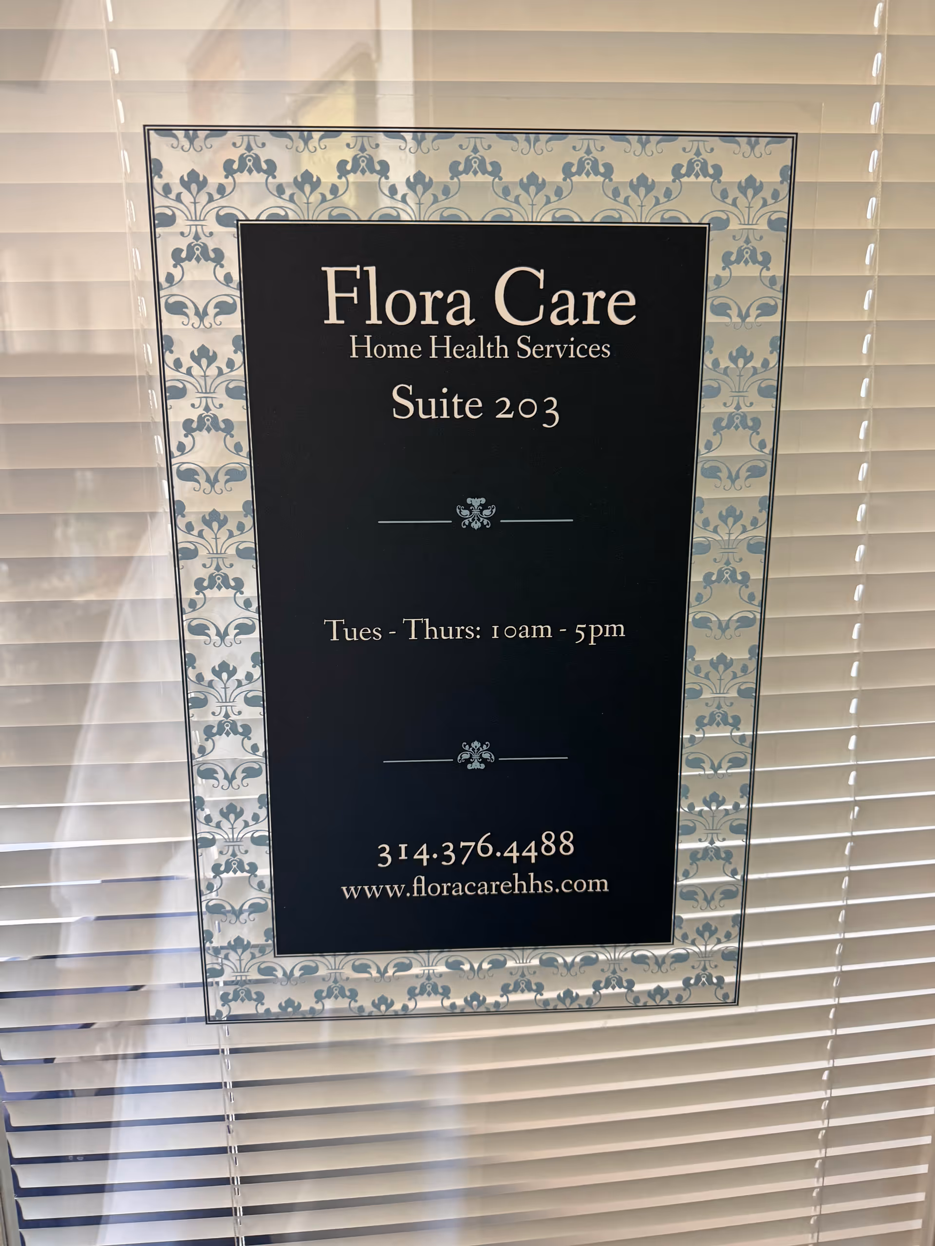 Flora Care Home Health Services Suite 203 sign framed by a decorative border.