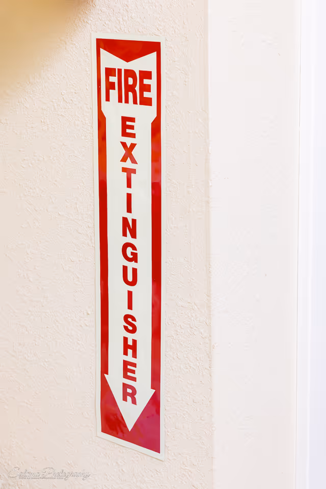 Vertical red Fire Extinguisher sign on beige interior wall.