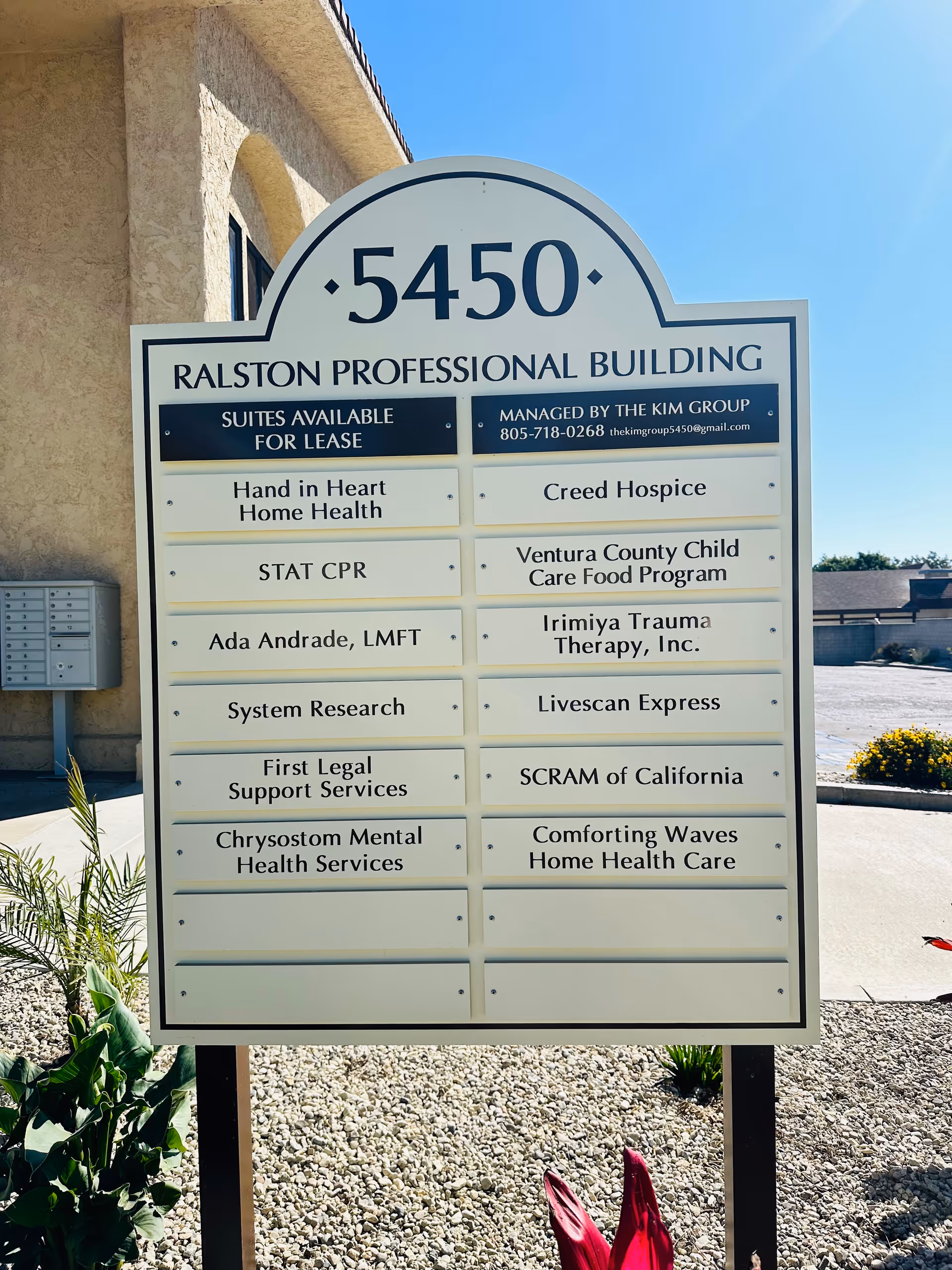 Outdoor signboard displaying multiple business names for a professional building, including Comforting Waves Home Health Care.