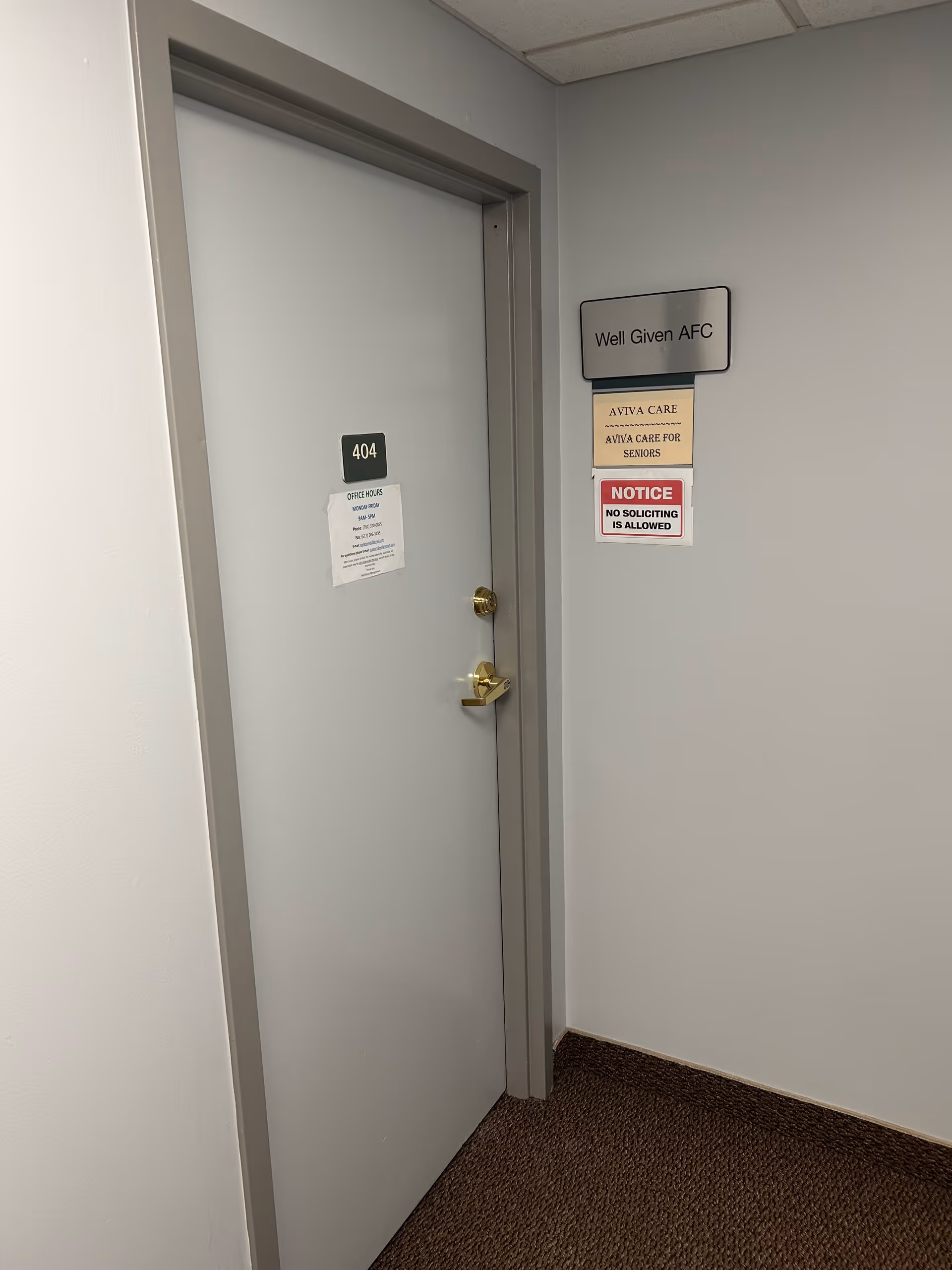 Interior hallway with a gray door labeled 404 and wall signs.