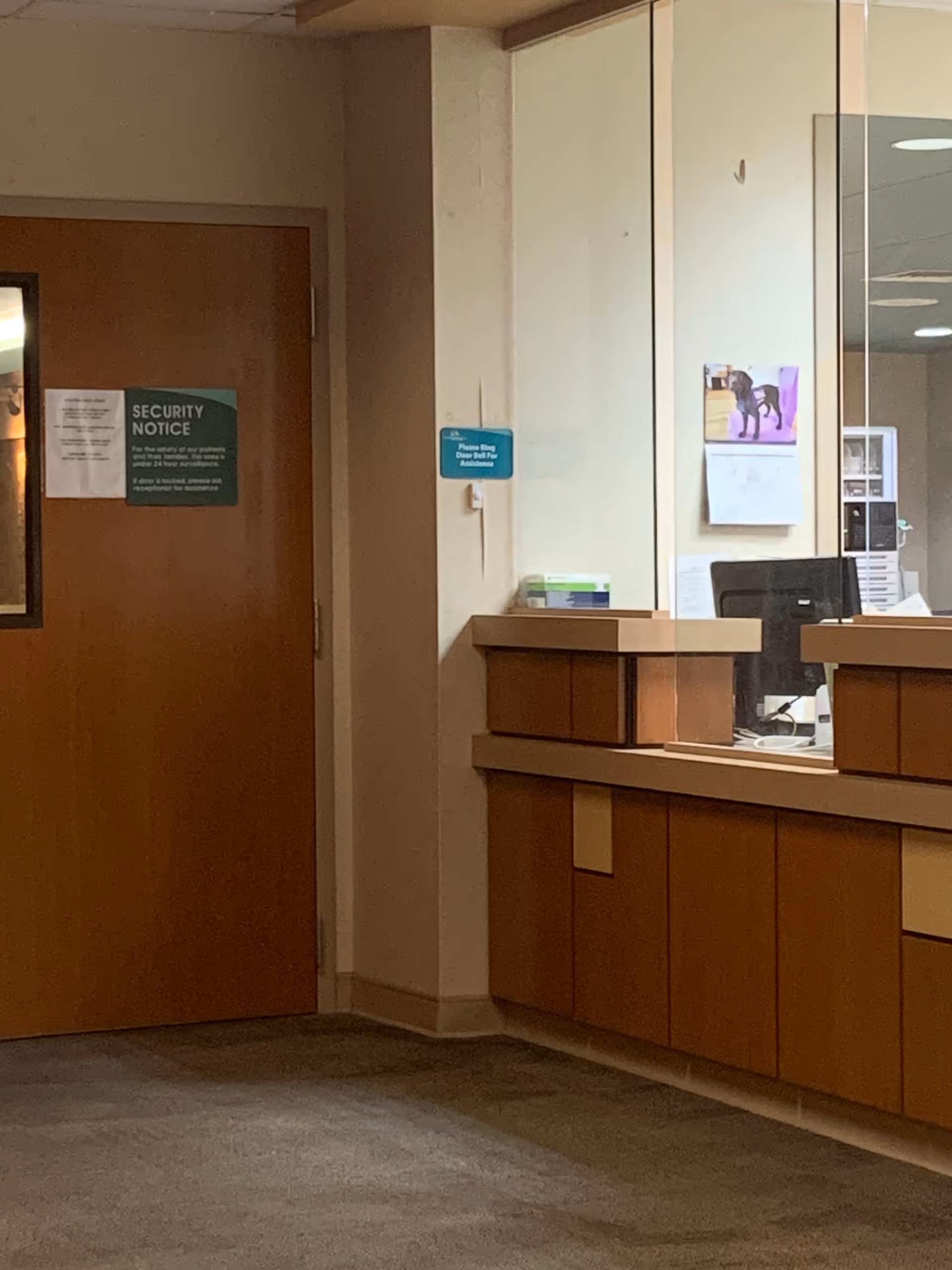 Reception desk inside a Jennie Stuart Health facility with a security notice on the door.