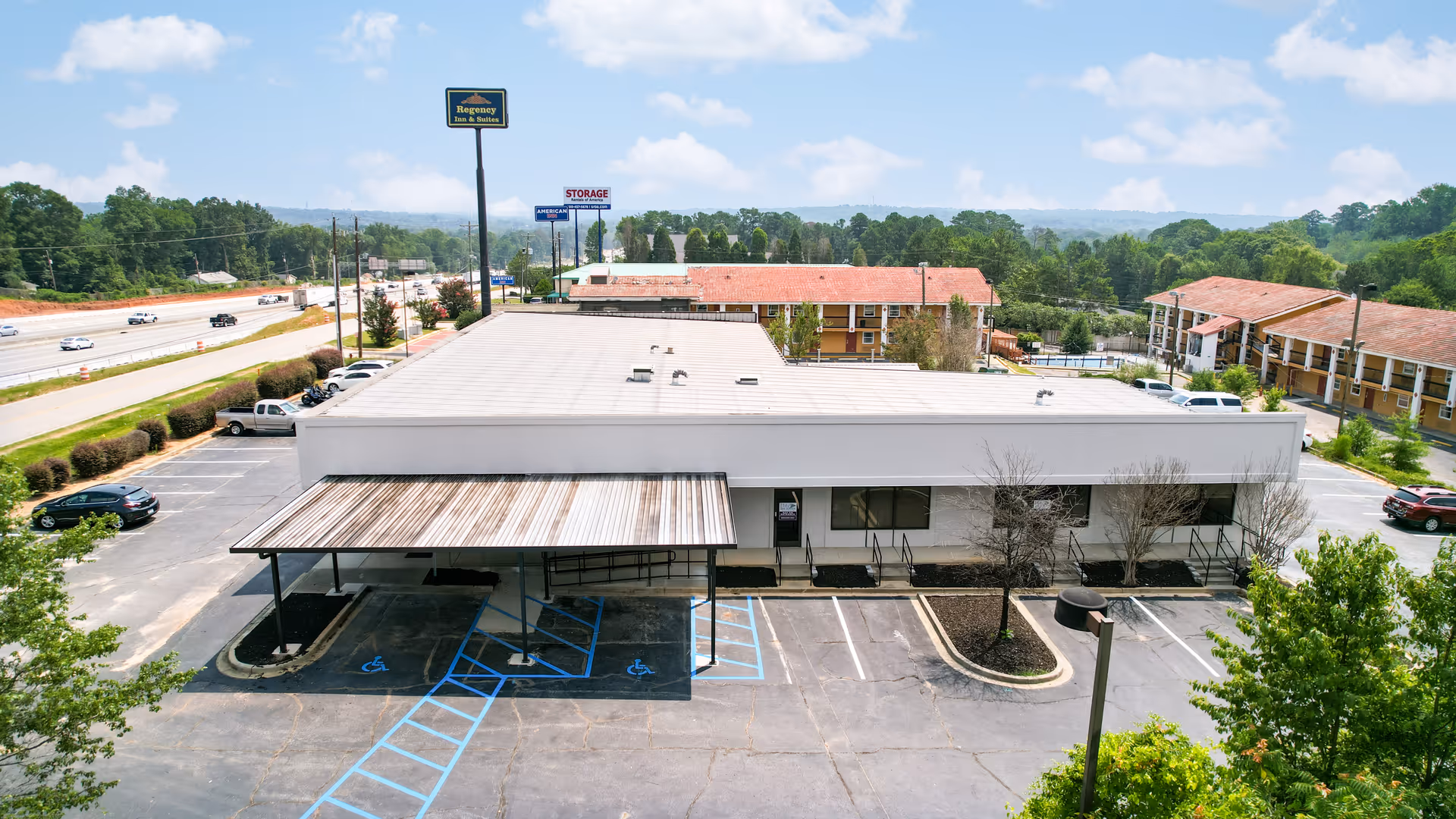 A single-story building with a covered entrance and marked parking spaces in front.