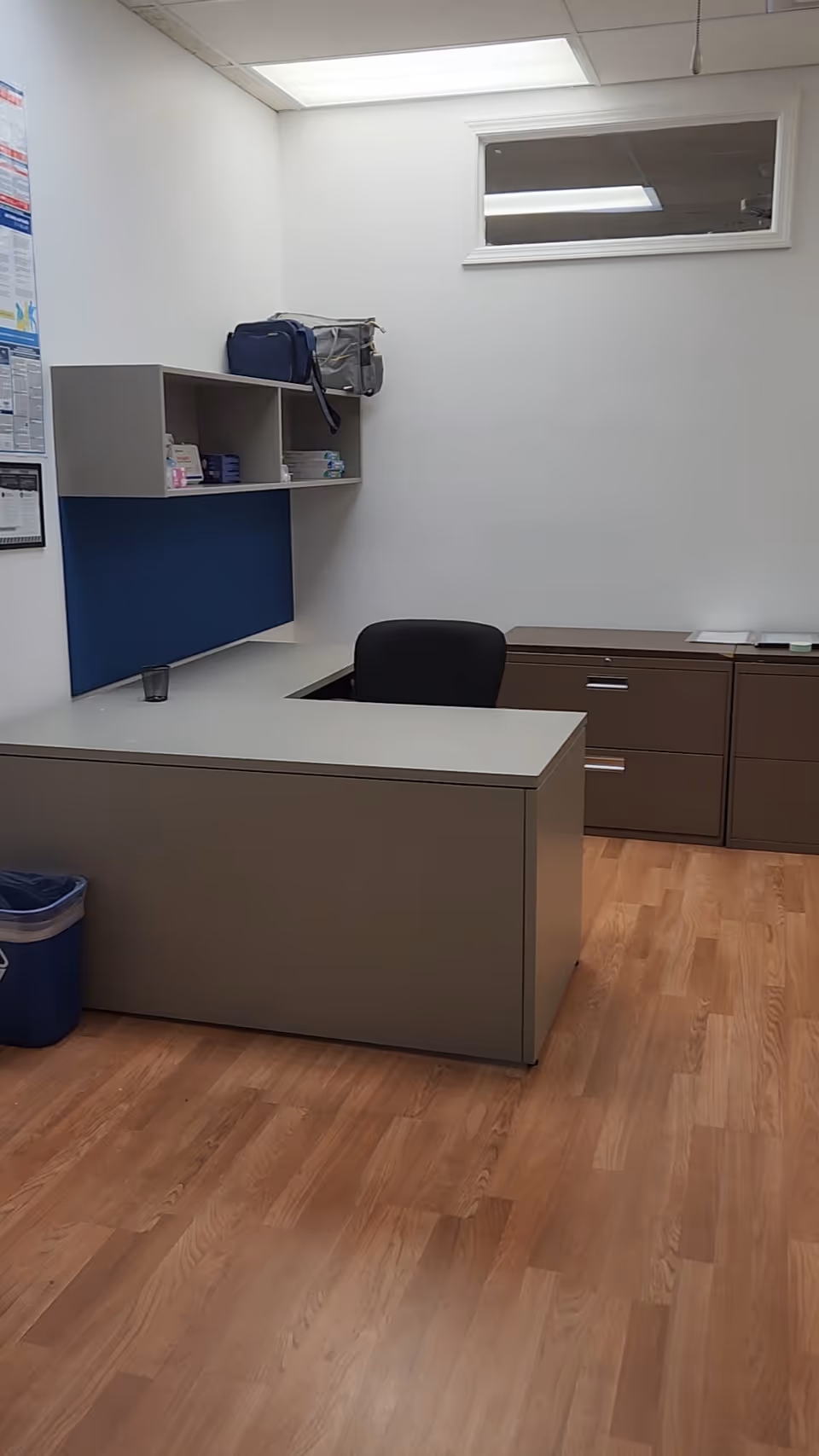 An interior reception area with a desk, shelves, and cabinets.