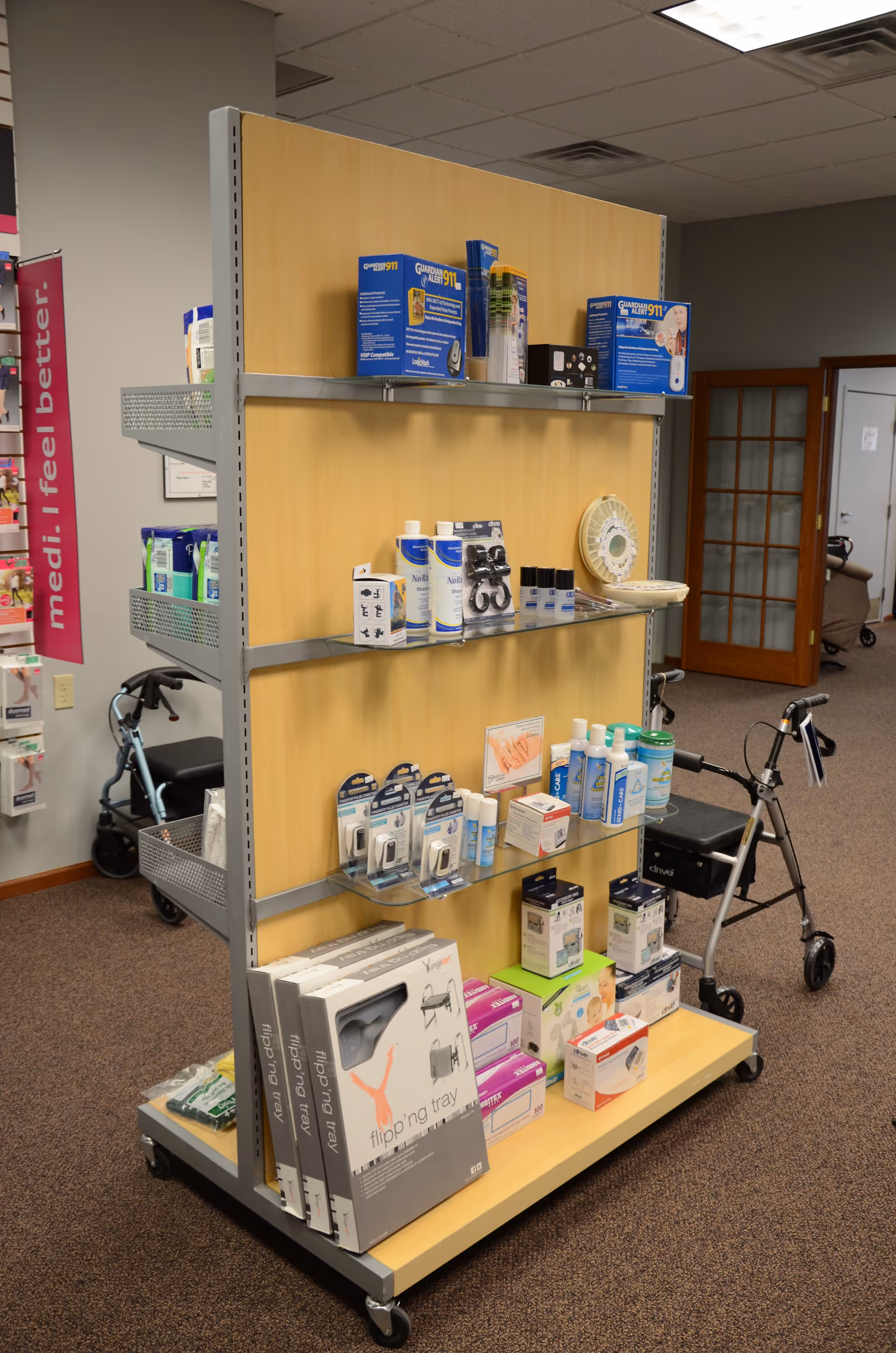 A wheeled display cart stocked with medical supplies inside a senior care facility.