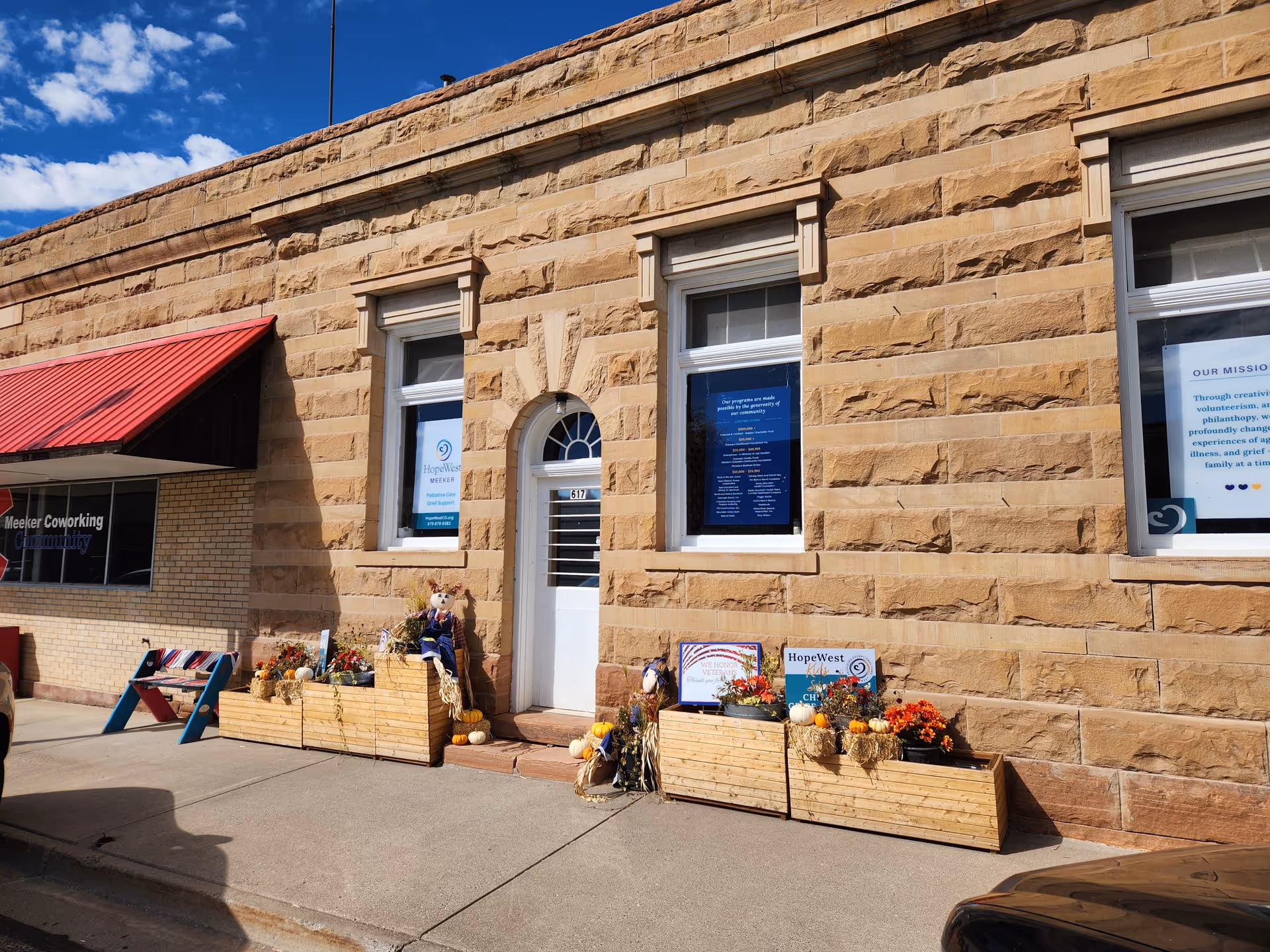 Stone-front building with HopeWest Administrative Offices entrance and window displays.