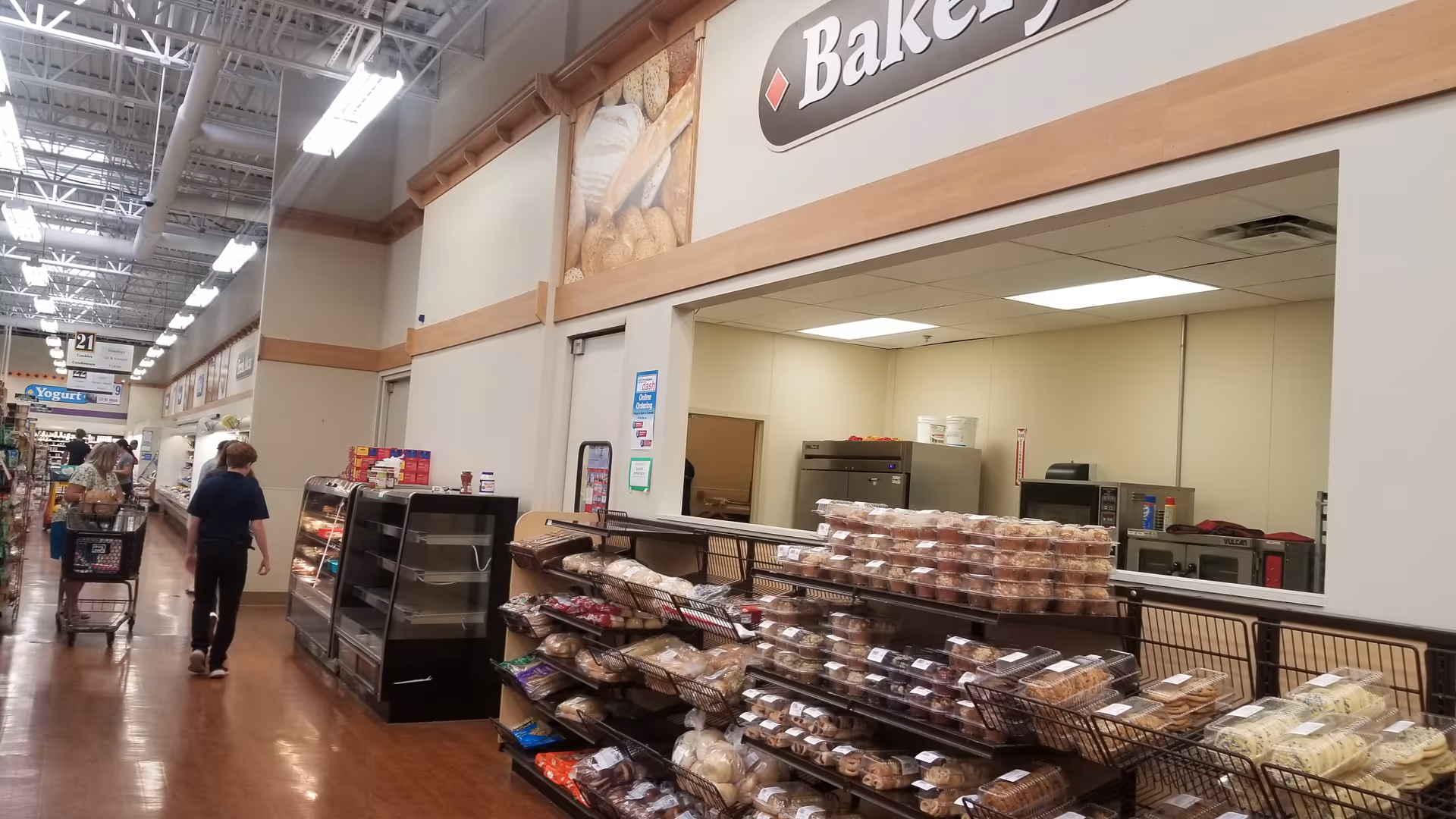 Interior of Discount Drug Mart bakery area with customers browsing shelves.
