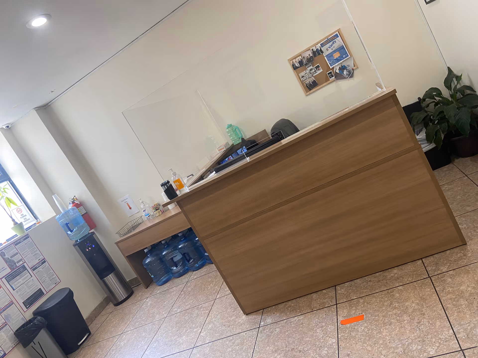 Reception desk at Royal Care senior living lobby with water cooler and bulletin board.