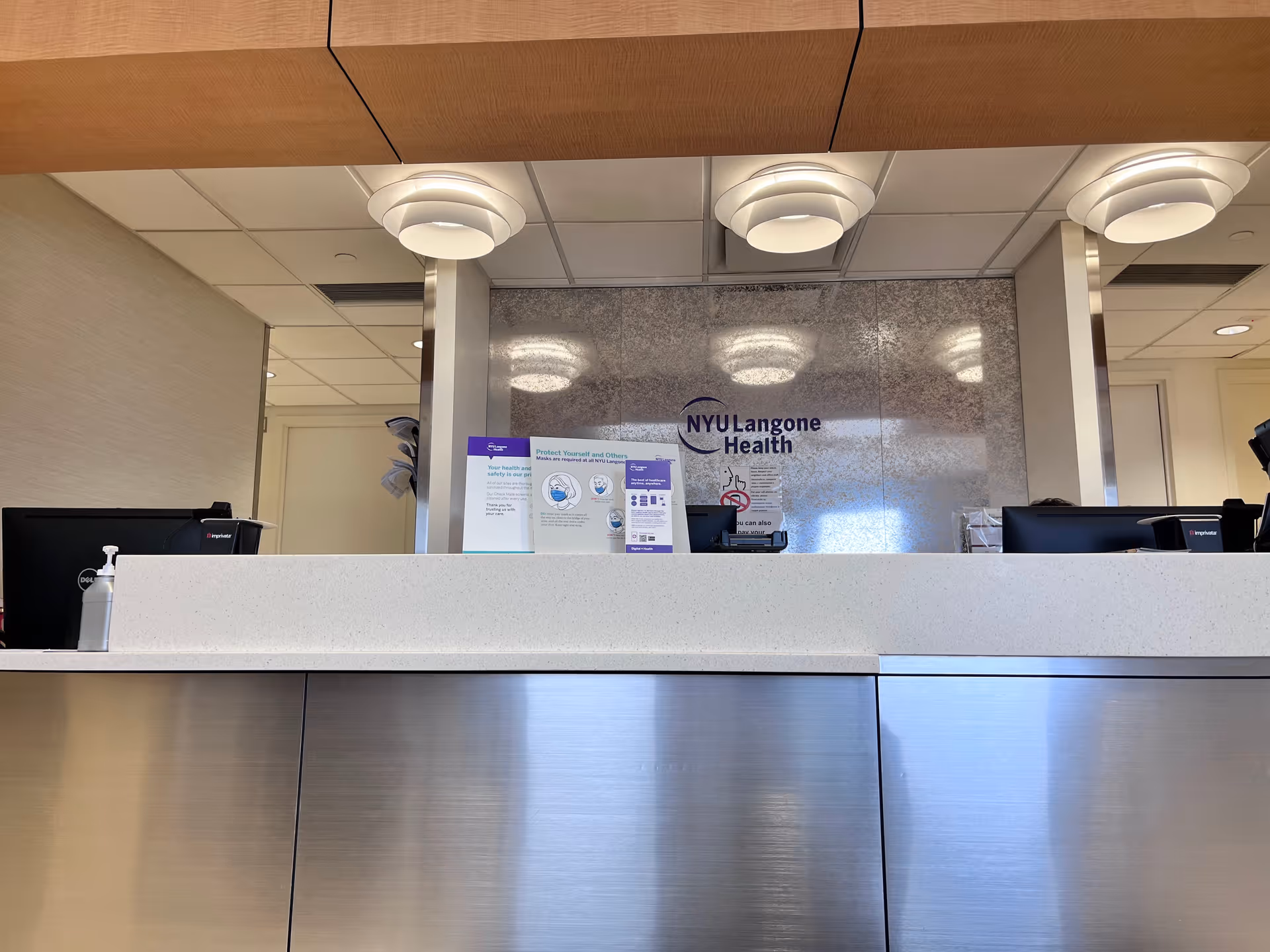 Reception desk in a medical facility lobby with NYU Langone Health signage.