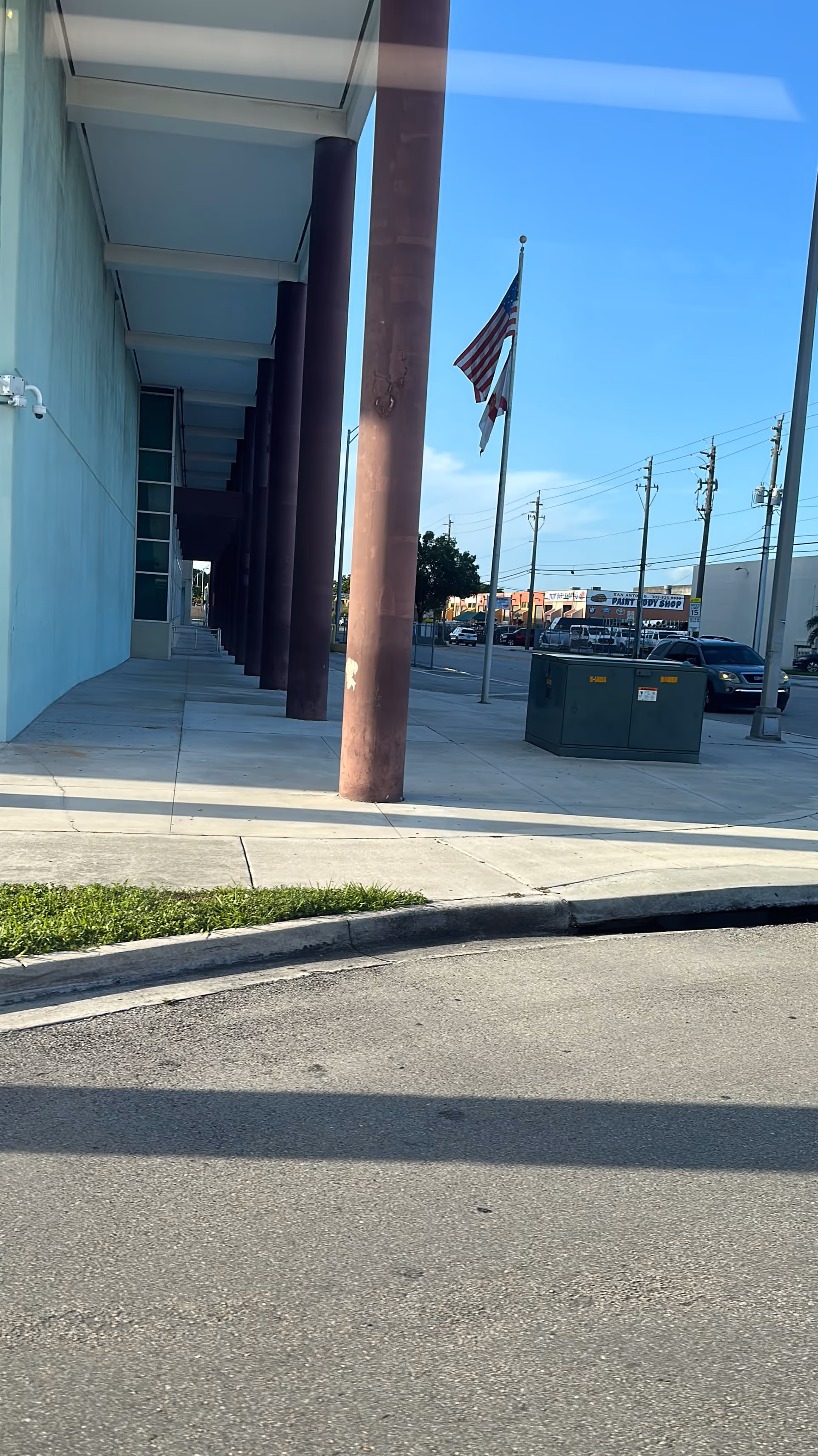 Exterior view of Versalles Home Health Medical building with maroon columns and flag.