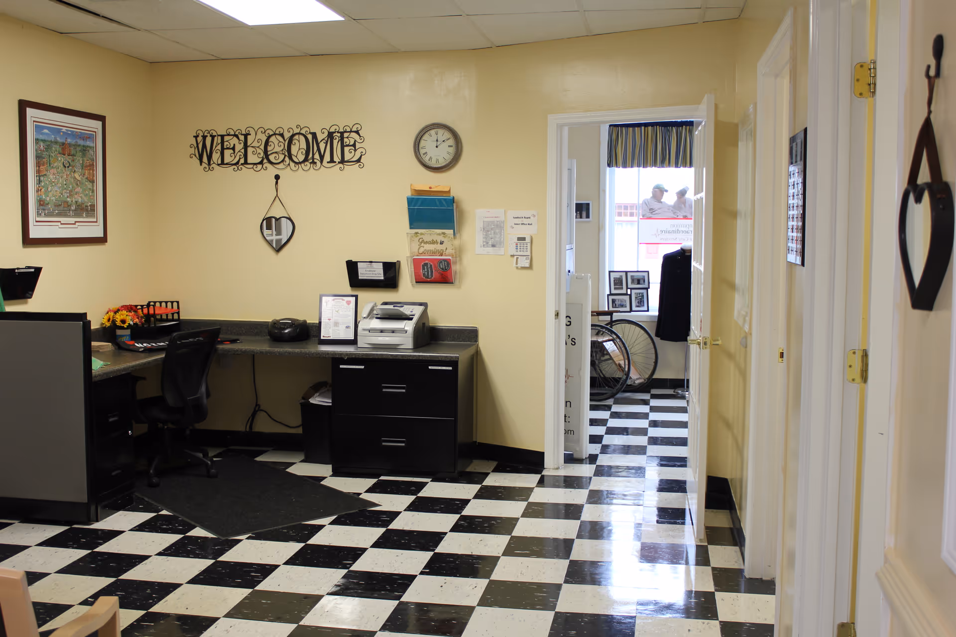 Reception lobby with a Welcome sign, clock, and checkered tile floor.