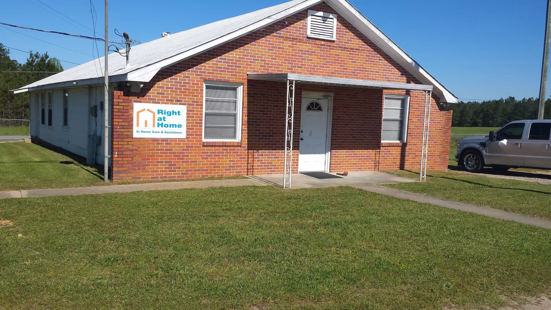 Brick one-story senior care building with Right at Home sign and front porch entrance.