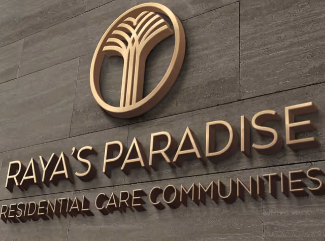 Exterior view of Raya's Paradise sign on a gray wall at the facility front.