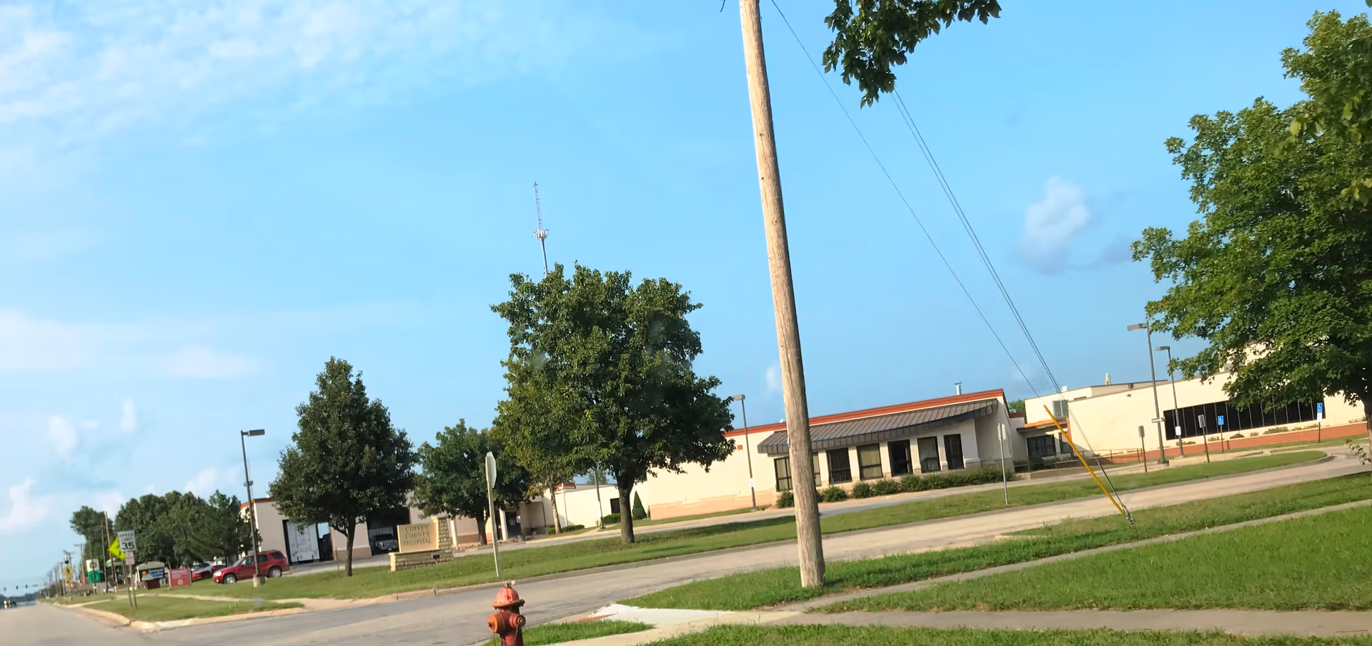 Exterior view of Coffey County Hospital campus with trees, street, and low-rise buildings.