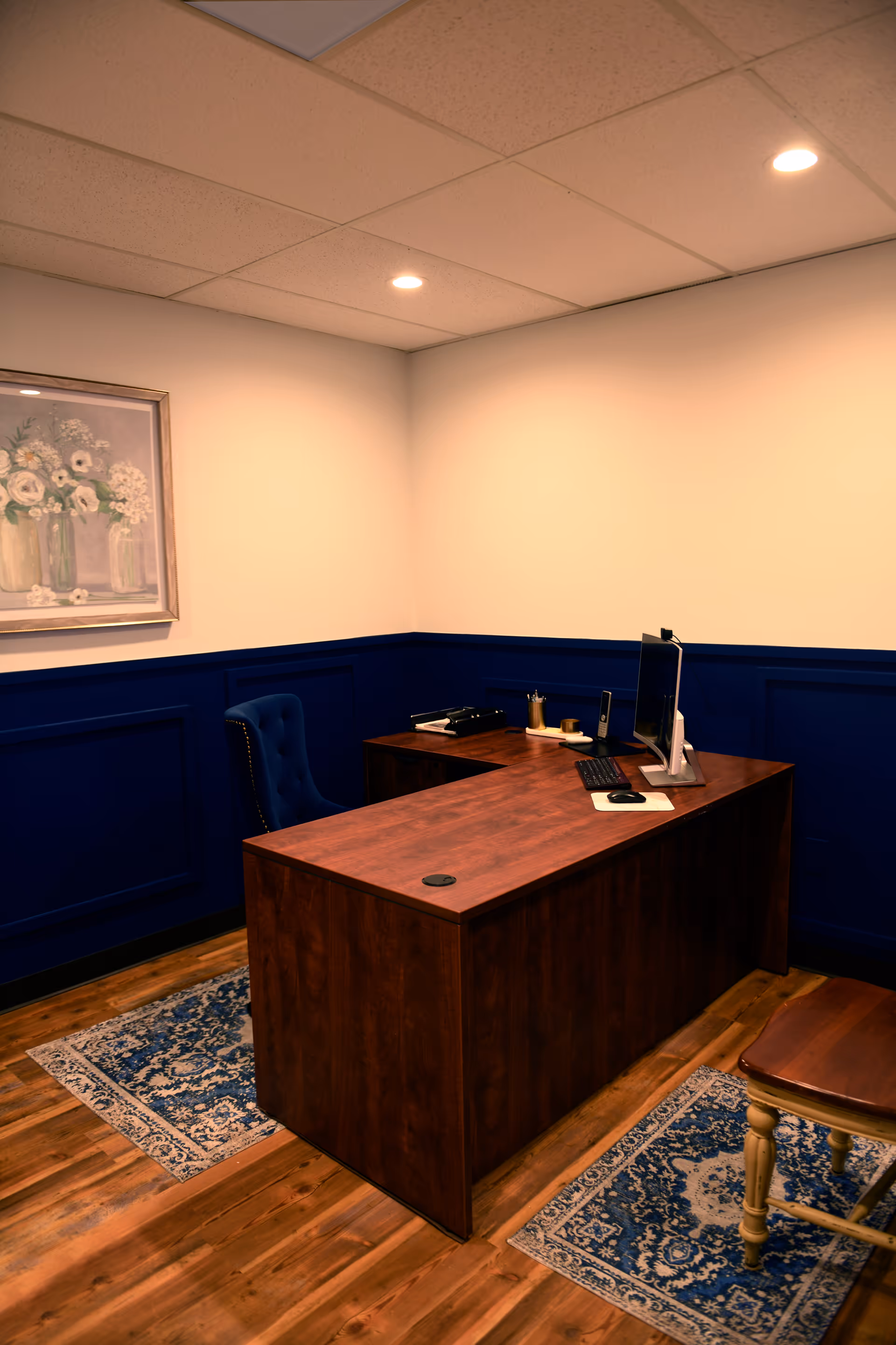 Wooden desk with computer in a small interior office of a senior living facility.