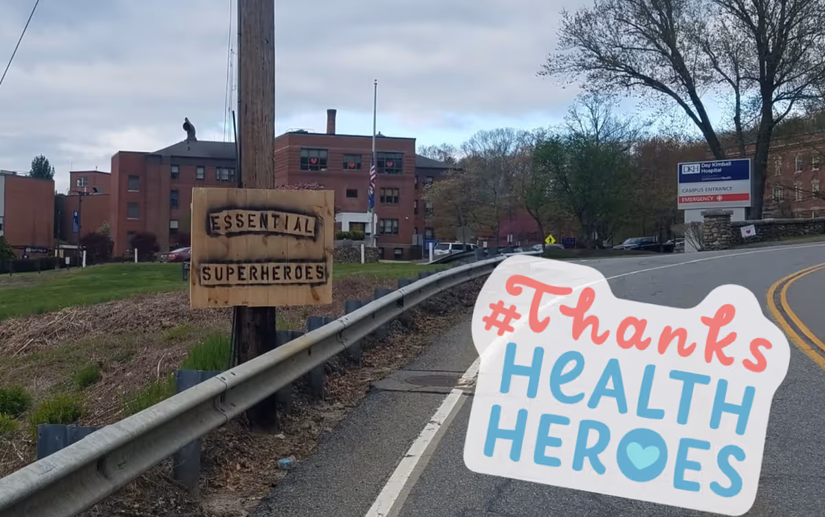 Exterior view of Day Kimball Healthcare campus with a wooden Essential Heroes sign by the road