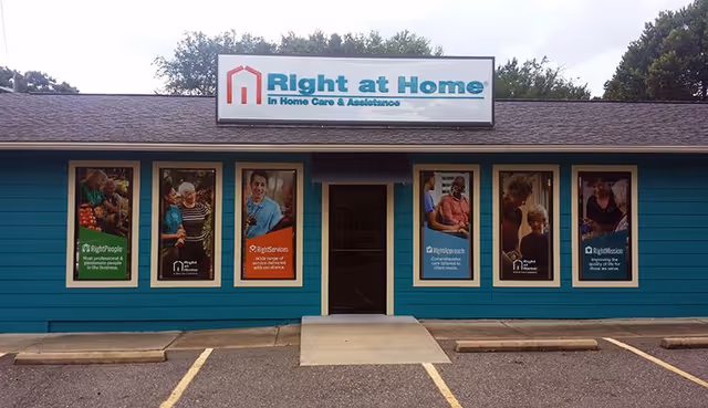 Front view of a turquoise Right at Home facility with posters in windows and sign.