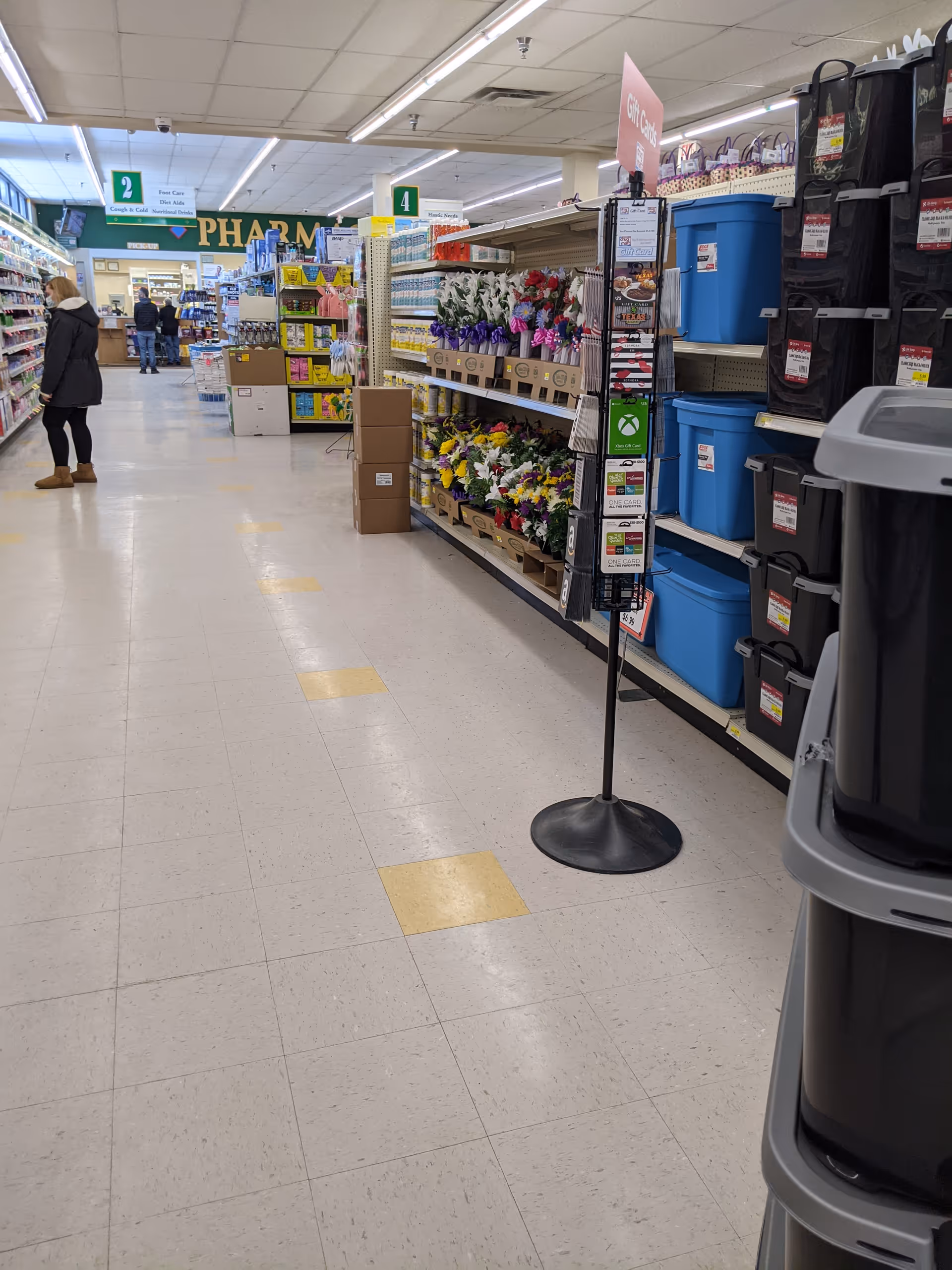 Aisles in Discount Drug Mart store with shoppers and organized shelves.