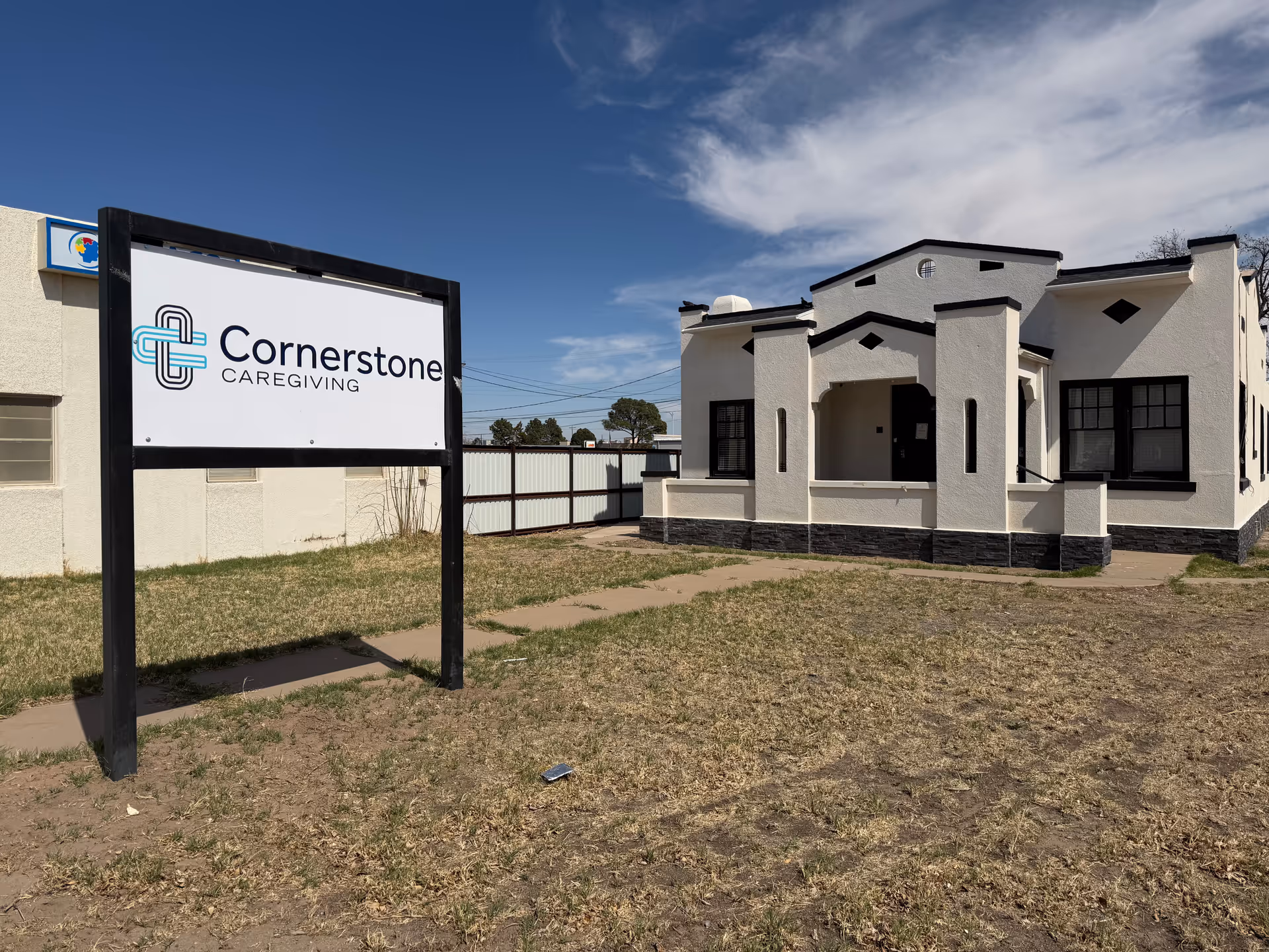 Cornerstone Caregiving building front featuring a sign and modern white exterior.