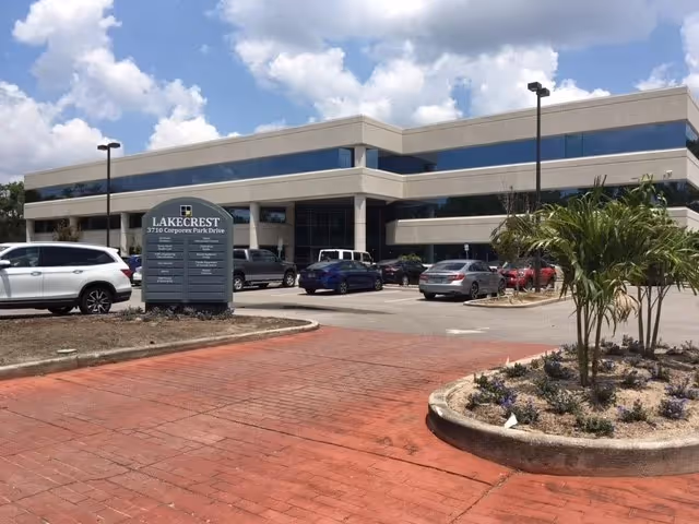 Exterior view of Lakecrest care facility with parking lot and landscaped island.
