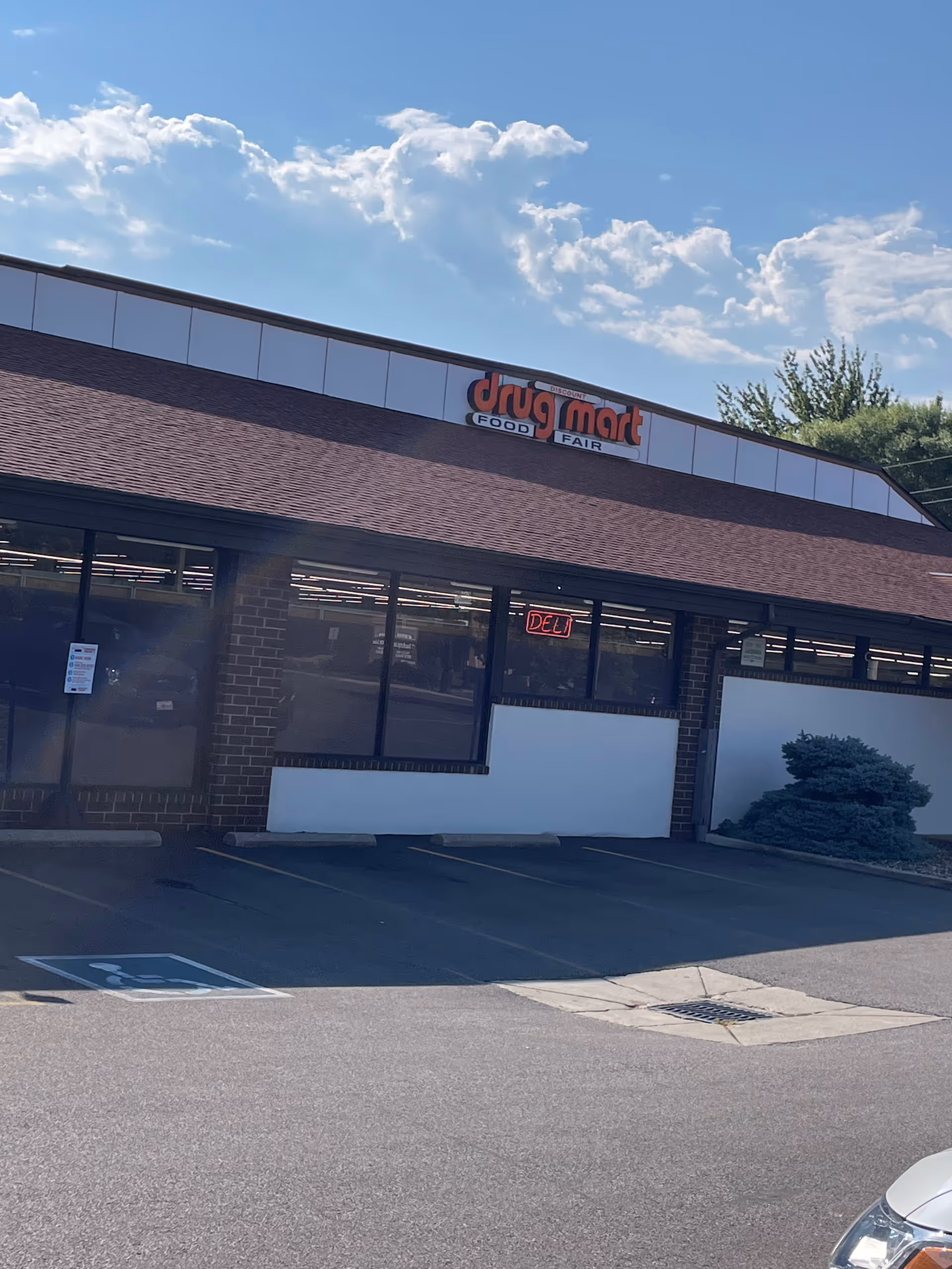 Exterior view of Discount Drug Mart storefront with brick facade and parking lot.