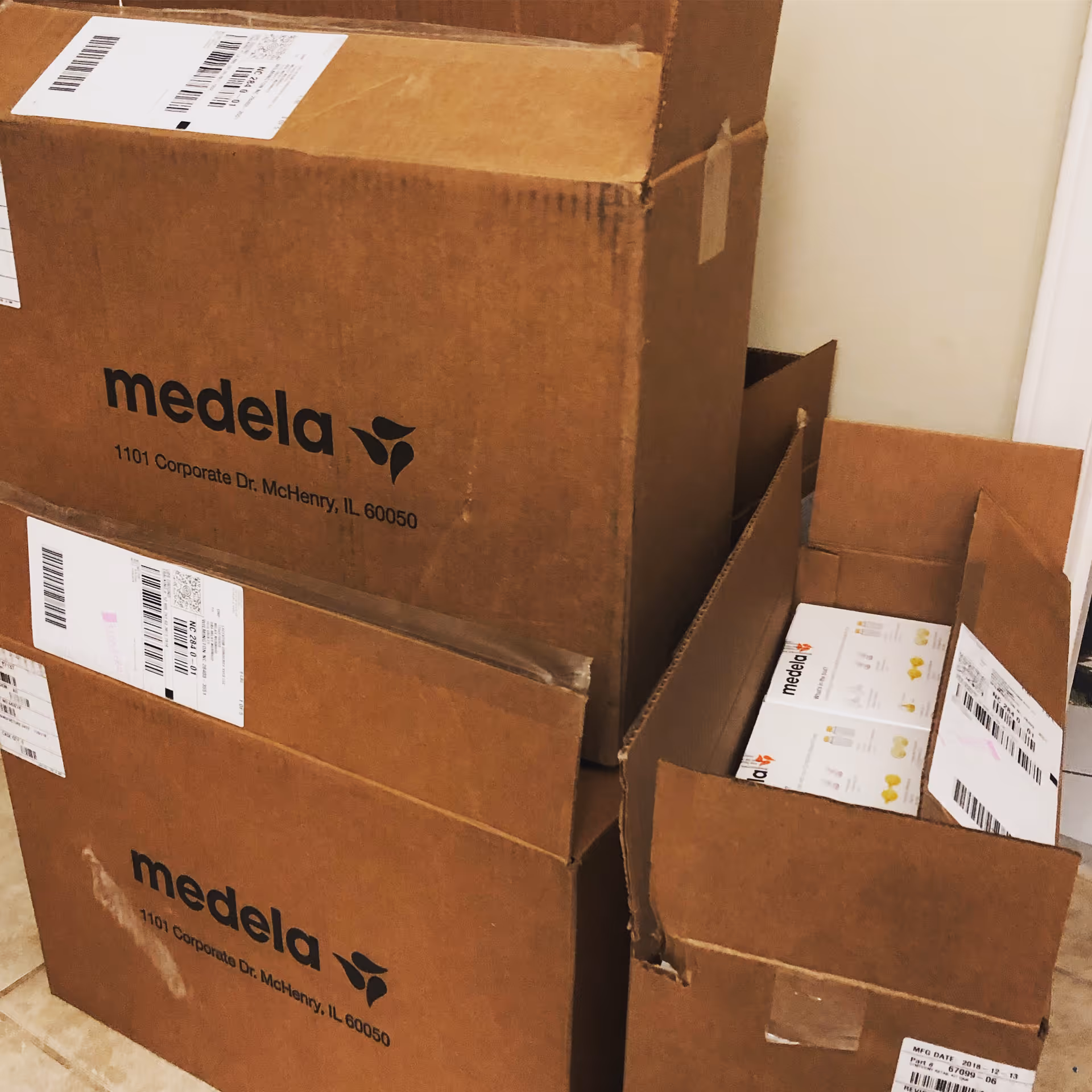 Stack of Medela boxes in a storage corner of an interior room.