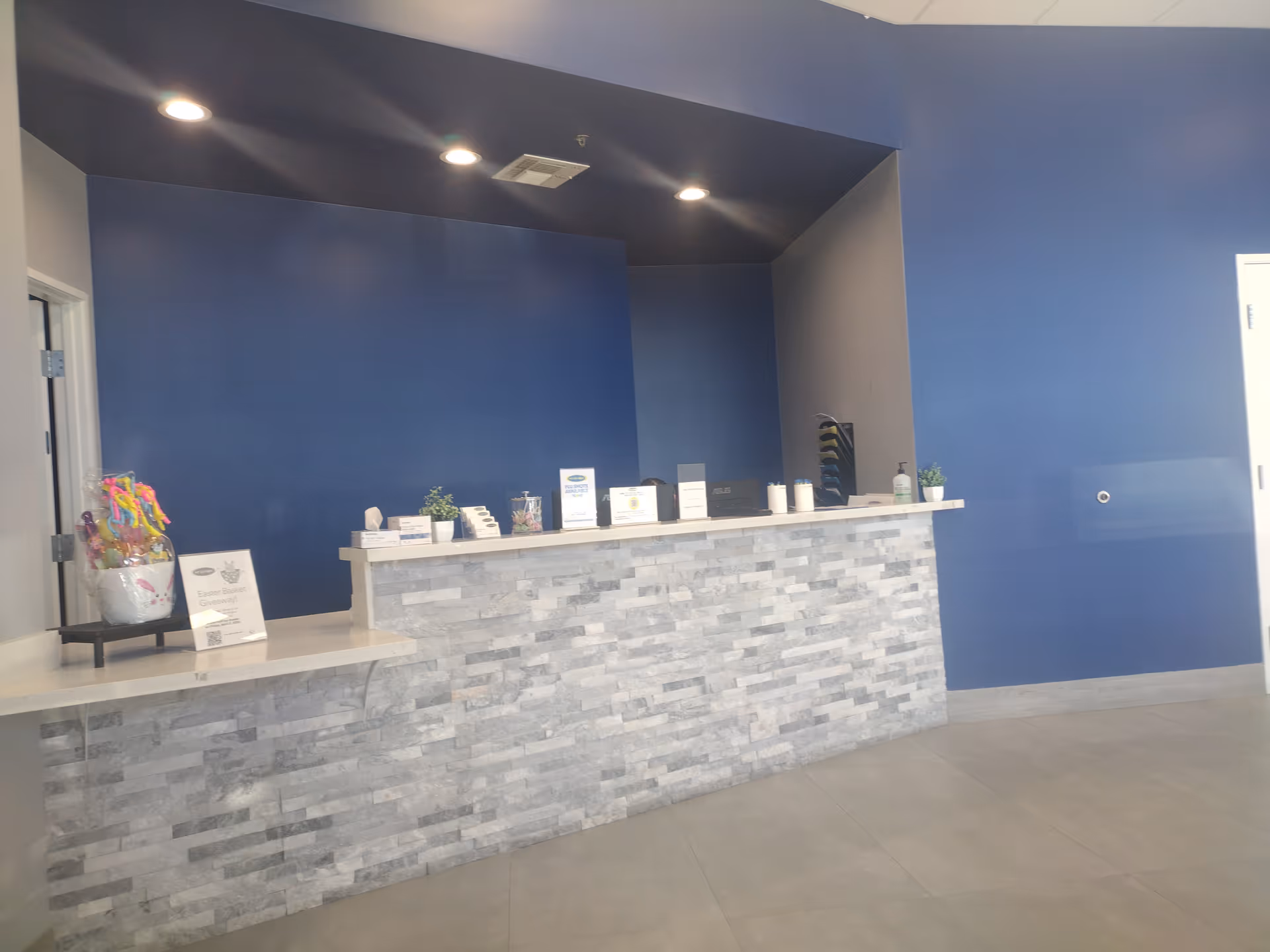 Reception desk with a stone facade against blue walls in a modern interior.