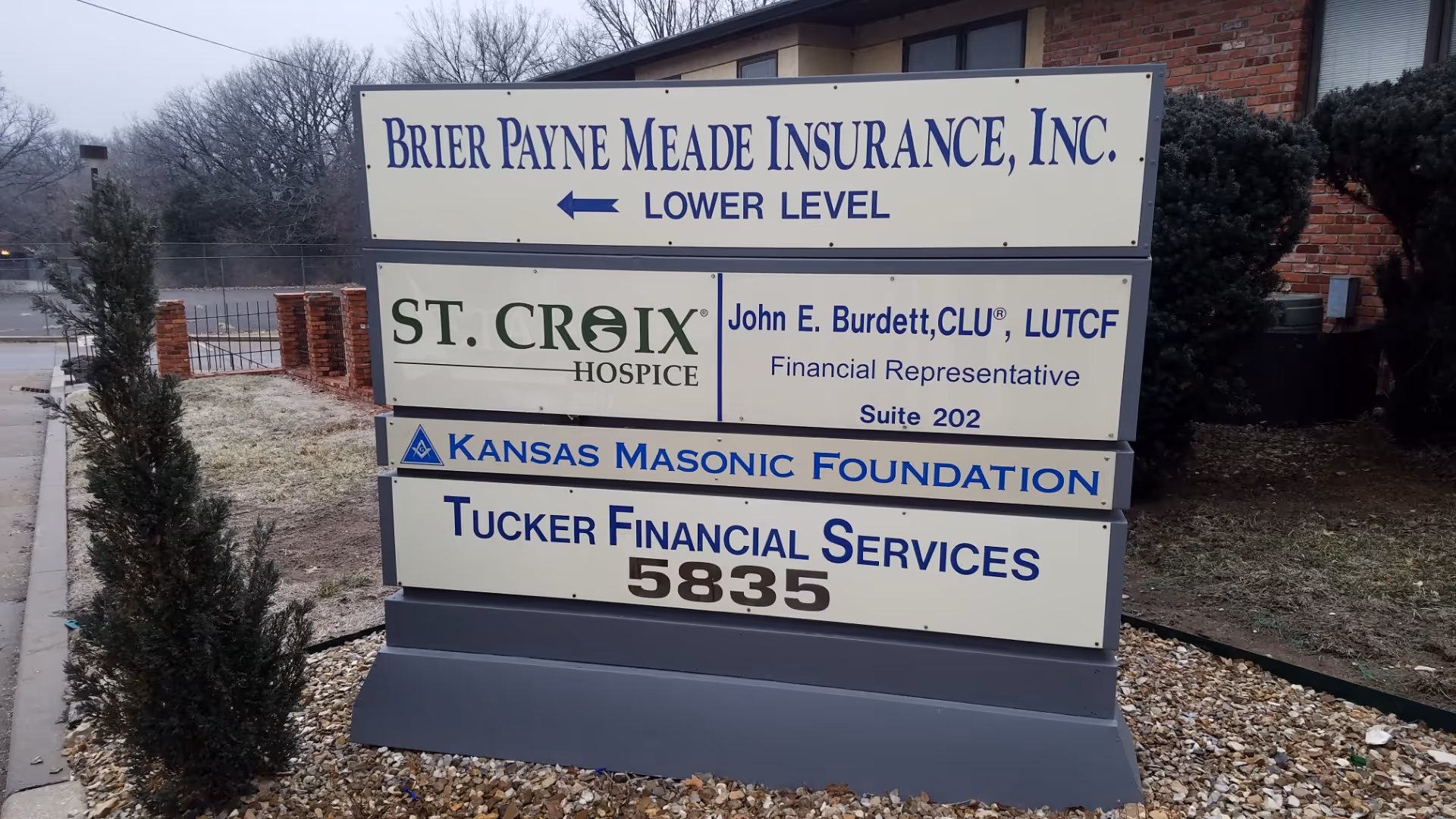 Outdoor sign cluster in front of brick building advertising St. Croix Hospice and other services.